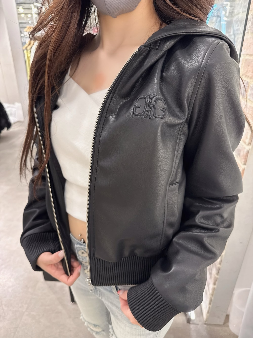 ブルー系のデニムパンツ、ホワイト系のTシャツ/カットソー、ブラック系のブルゾンを着用したレディースの春コーディネートの4枚目の写真