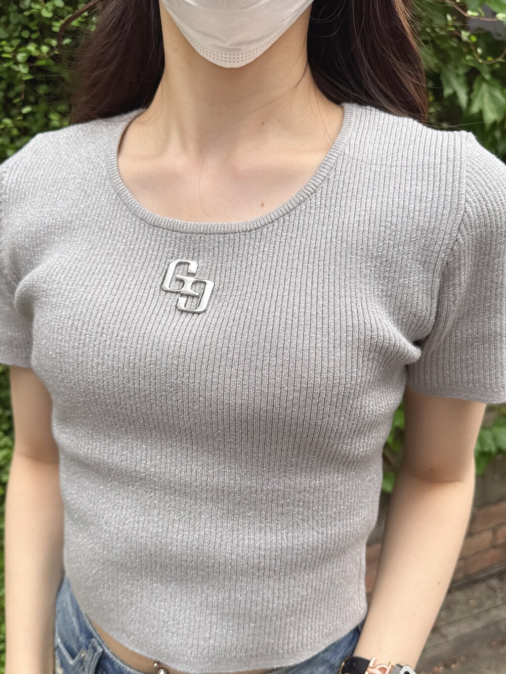 シルバー系のニット/セーター、ブルー系のデニムスカート、ホワイト系のサンダルを着用したレディースの春コーディネートの4枚目の写真