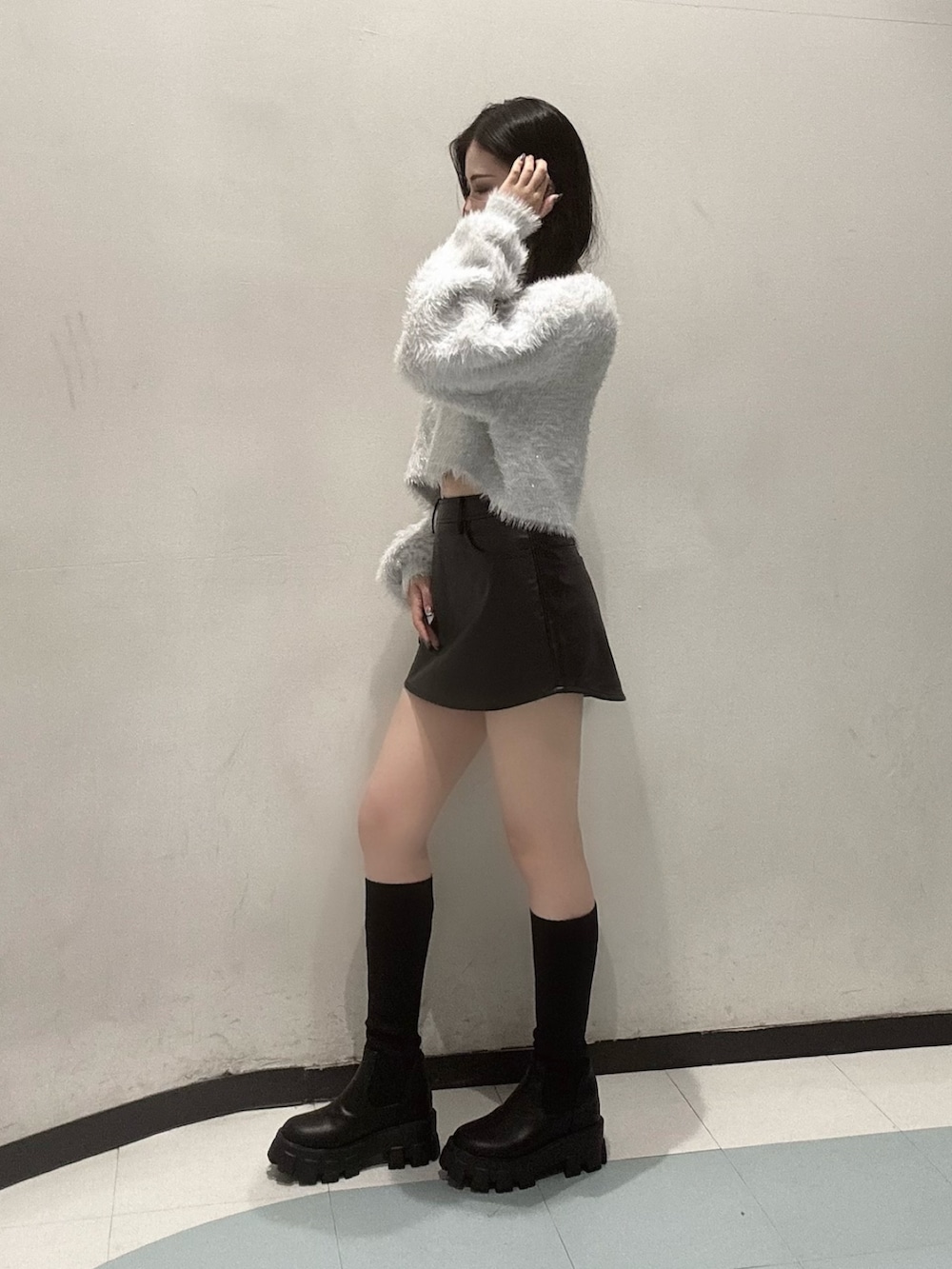 ホワイト系のカーディガン/ボレロ、ホワイト系のキャミソール、ブラック系のスカートを着用したレディースの秋コーディネートの2枚目の写真