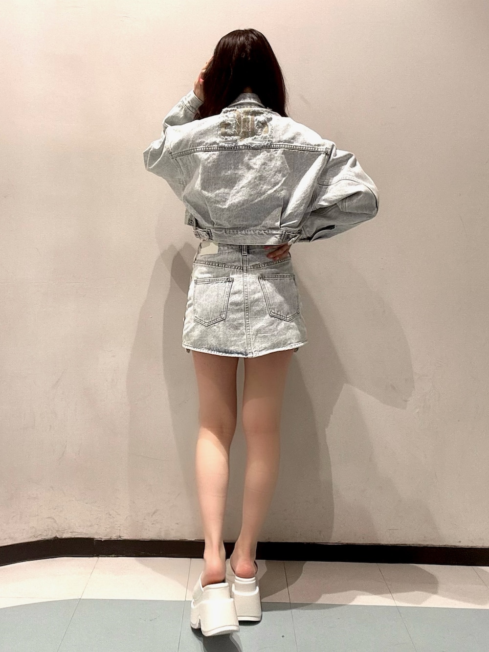 ホワイト系のTシャツ/カットソー、ブルー系のデニムジャケット、ブルー系のデニムスカートを着用したレディースの春コーディネートの3枚目の写真