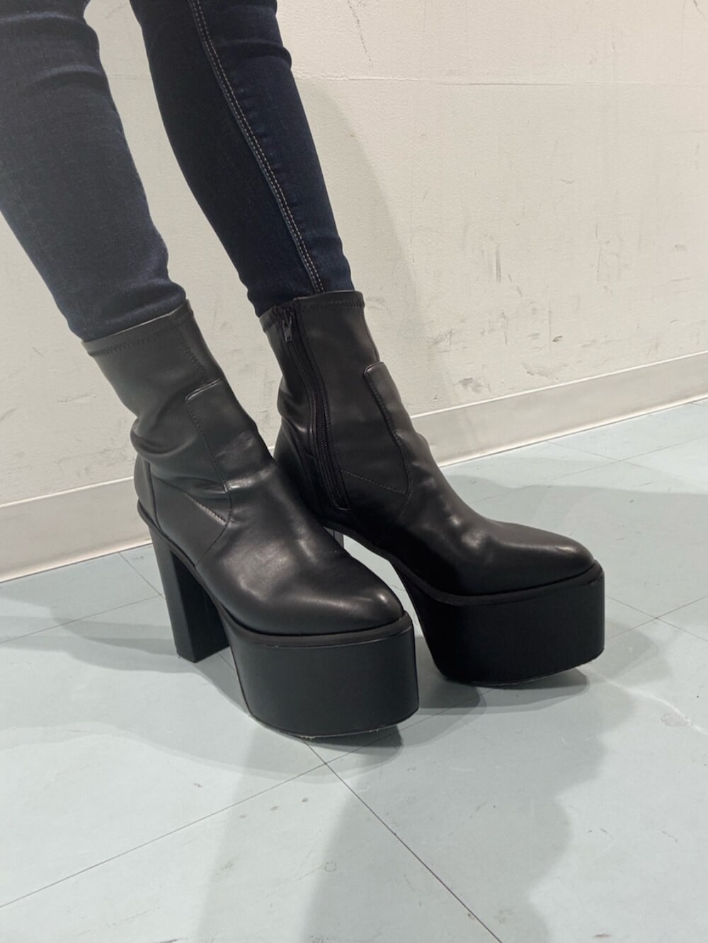 ブラック系のブーツ、ブルー系のデニムパンツ、ホワイト系のニット/セーターを着用したレディースの秋コーディネートの6枚目の写真