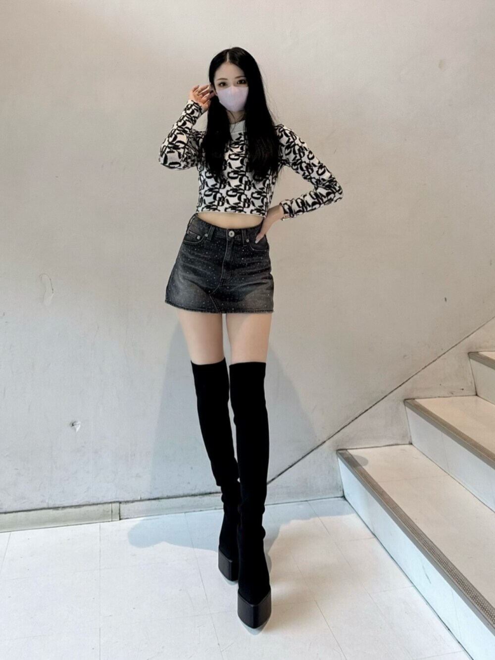 ホワイト系のニット/セーター、ブラック系のデニムスカート、ブラック系のダウンジャケット/コートを着用したレディースの秋コーディネートの5枚目の写真