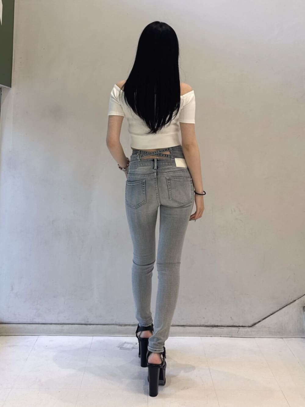 ホワイト系のTシャツ/カットソー、ブルー系のデニムパンツ、ブラック系のサンダルを着用したレディースの春コーディネートの3枚目の写真