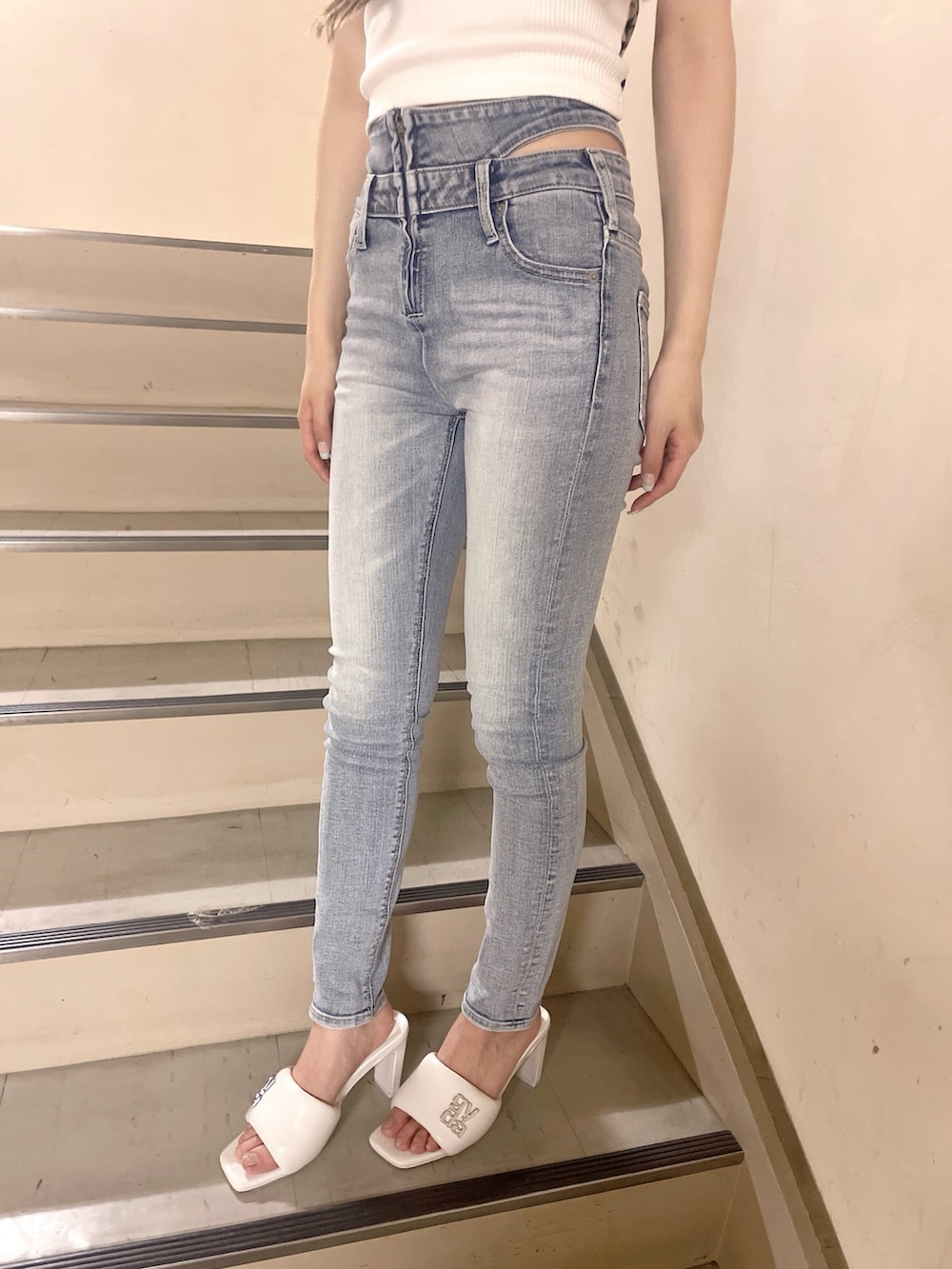 ブラック系のハンドバッグ、ブルー系のデニムパンツ、ホワイト系のTシャツ/カットソーを着用したレディースの春コーディネートの6枚目の写真