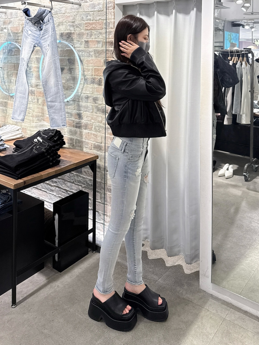 ブルー系のデニムパンツ、ホワイト系のTシャツ/カットソー、ブラック系のブルゾンを着用したレディースの春コーディネートの2枚目の写真