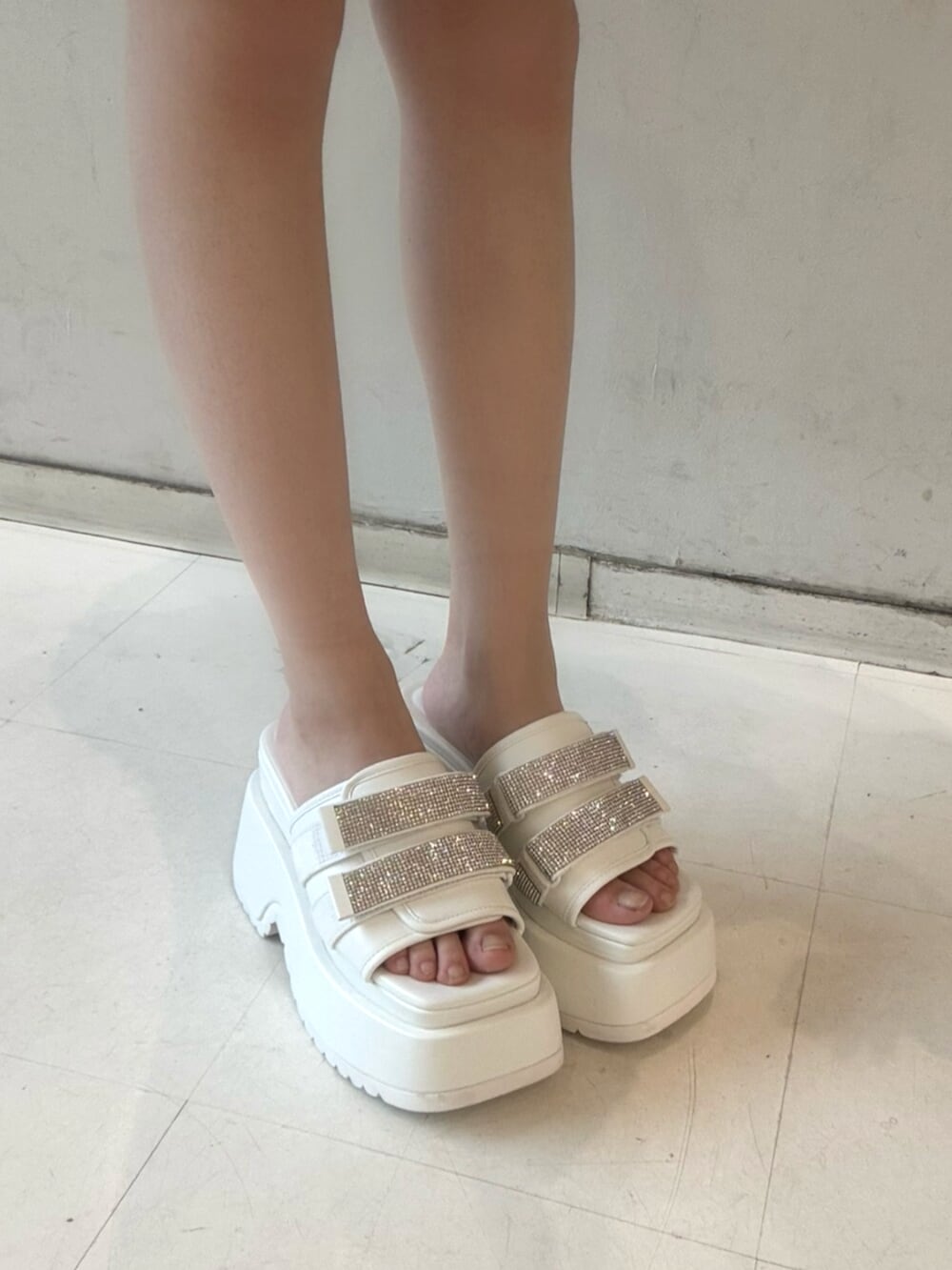 ブラック系のワンピース、グレー系のカーディガン/ボレロ、ホワイト系のサンダルを着用したレディースの春コーディネートの6枚目の写真