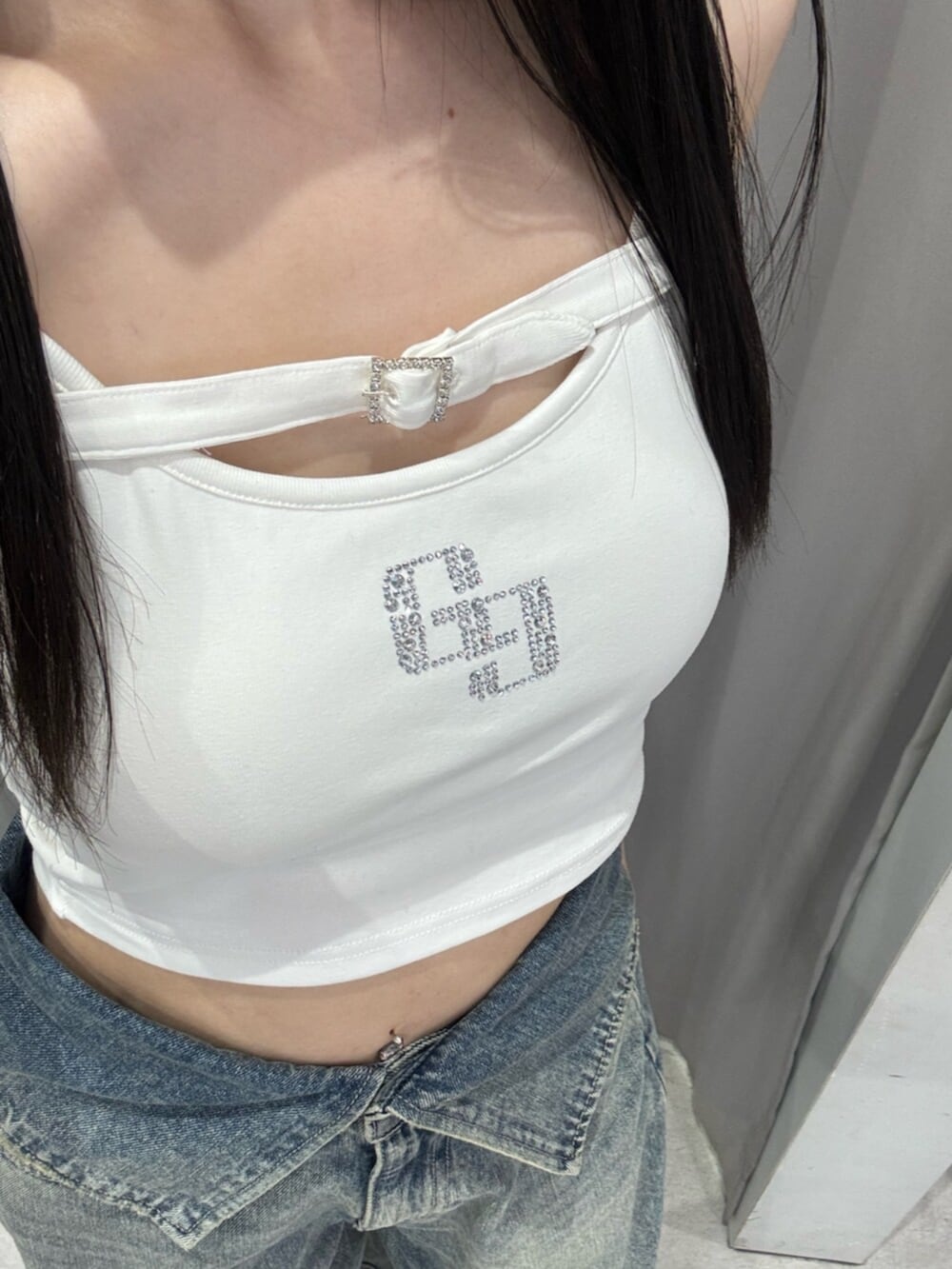 ブラック系のサンダル、ホワイト系のキャミソール、ブルー系のデニムパンツを着用したレディースの夏コーディネートの5枚目の写真