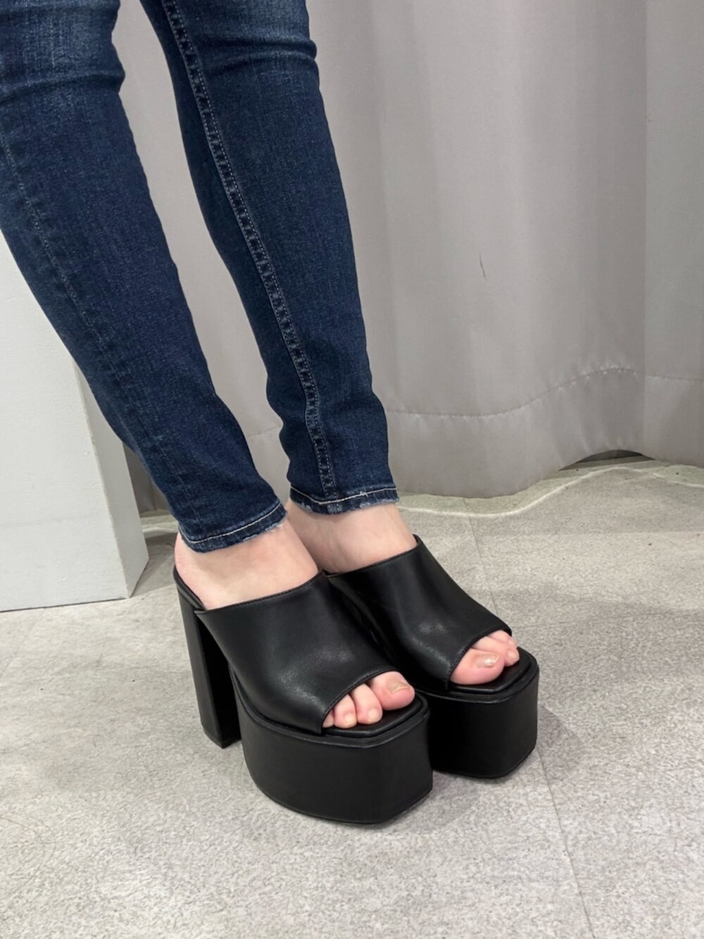 ホワイト系のタンクトップ、ブルー系のデニムパンツ、ブラック系のサンダルを着用したレディースの夏コーディネートの5枚目の写真