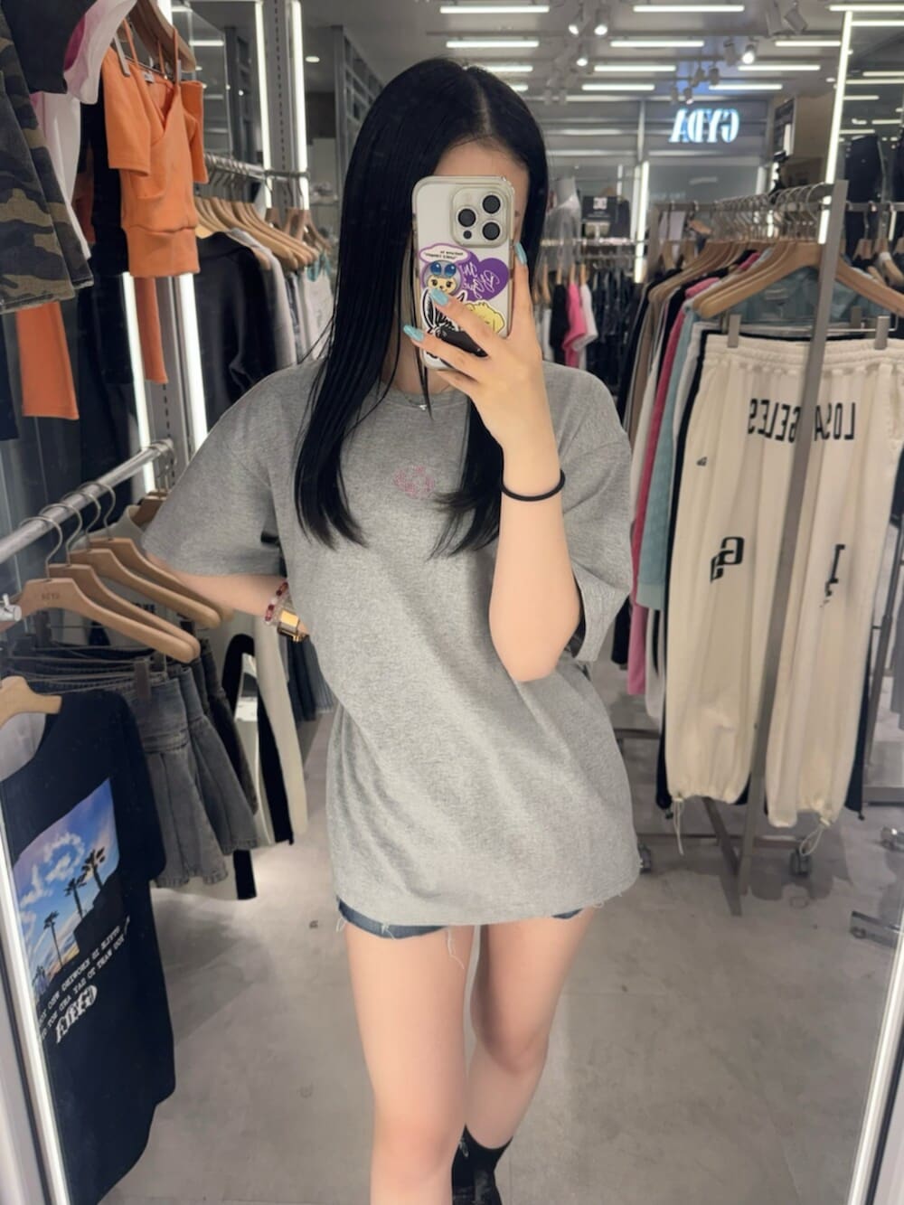 グレー系のTシャツ/カットソー、ブルー系のデニムパンツ、ブラック系のスニーカーを着用したレディースの春コーディネートの5枚目の写真