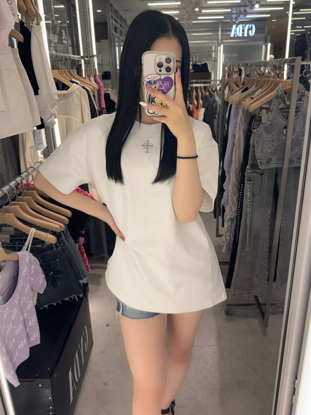ホワイト系のTシャツ/カットソー、ブルー系のデニムパンツ、ブラック系のサンダルを着用したレディースの春コーディネートの4枚目の写真