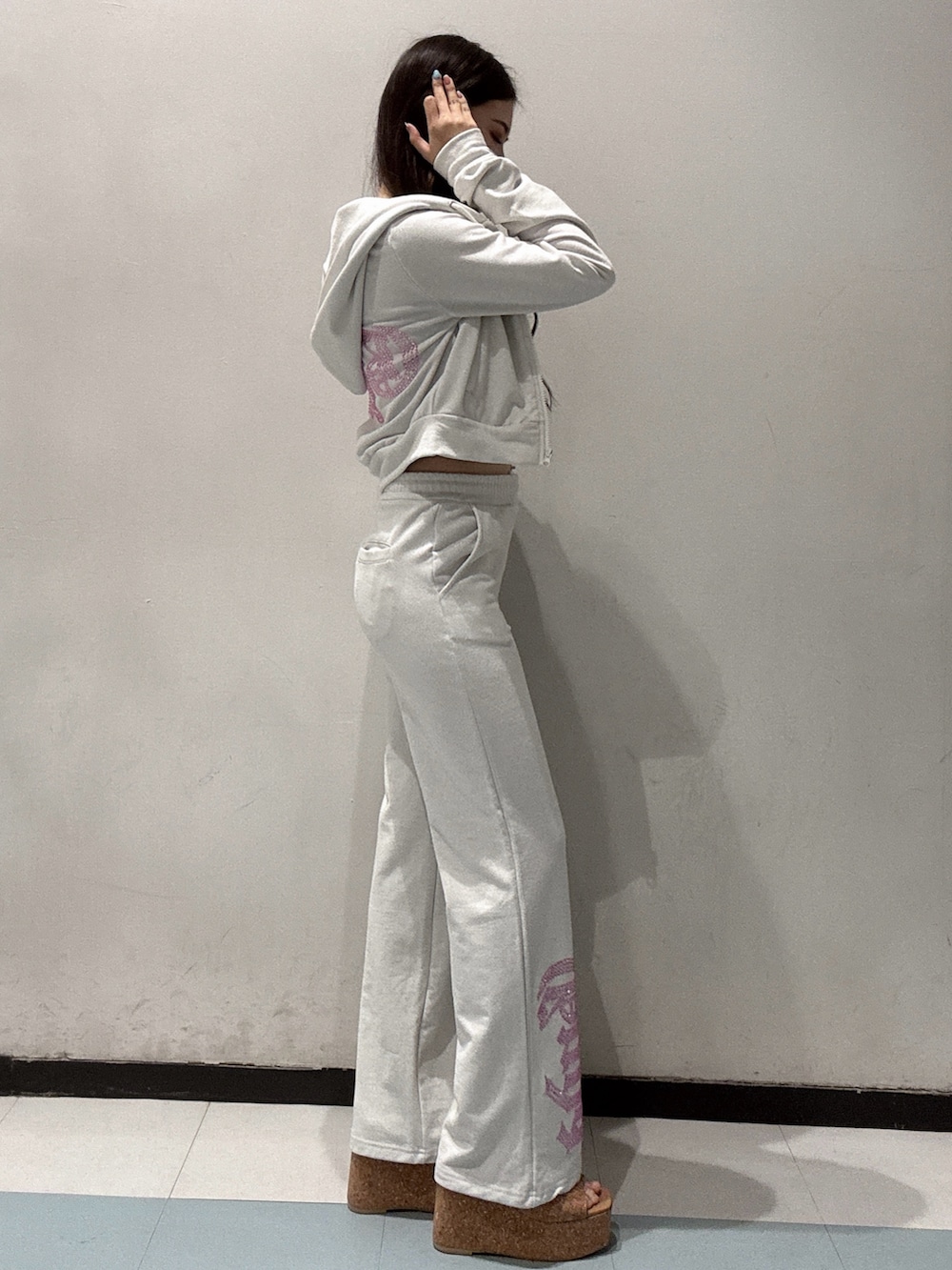 ブラック系のキャミソール、ホワイト系のパーカー、ホワイト系のスウェットパンツを着用したレディースの春コーディネートの2枚目の写真