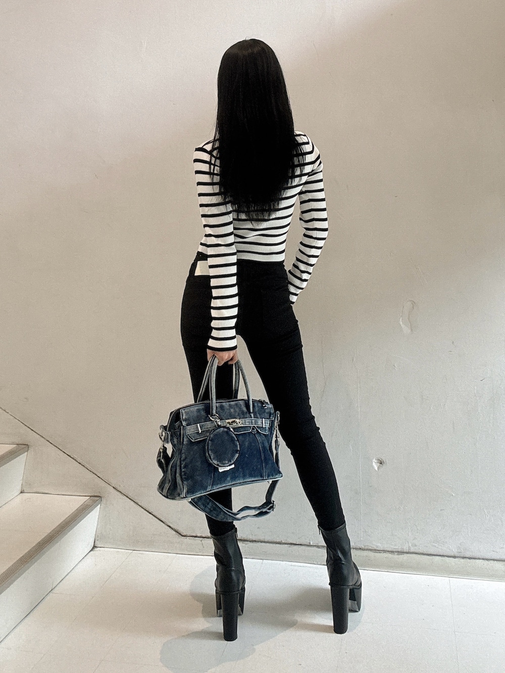 その他のニット/セーター、ブラック系のデニムパンツ、ブルー系のハンドバッグを着用したレディースの秋コーディネートの3枚目の写真