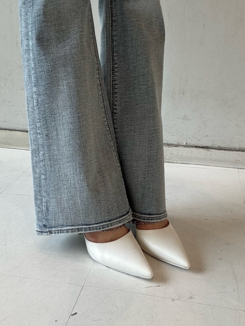ホワイト系のパンプス、ピンク系のキャミソール、ブルー系のデニムパンツを着用したレディースの春コーディネートの6枚目の写真