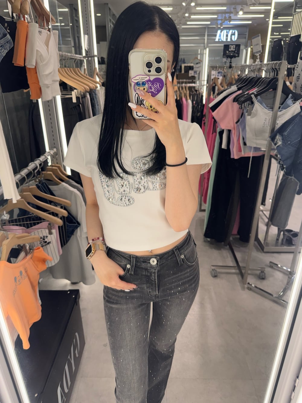 ホワイト系のTシャツ/カットソー、ブラック系のデニムパンツ、ブラック系のサンダルを着用したレディースの春コーディネートの5枚目の写真