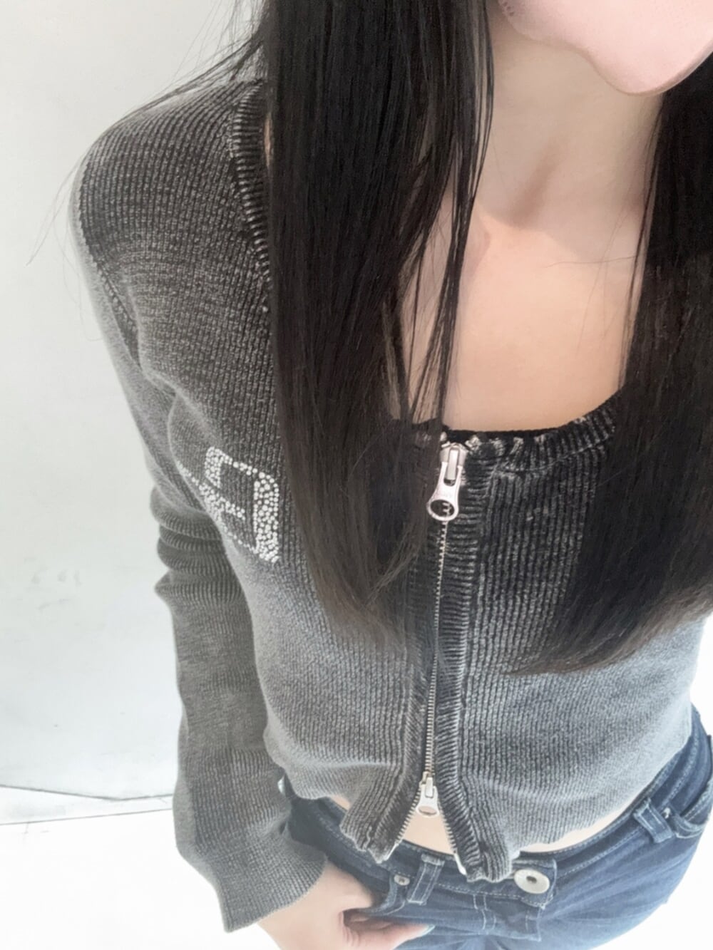 ブラック系のパンプス、ブラック系のニット/セーター、ブルー系のデニムパンツを着用したレディースの春コーディネートの4枚目の写真