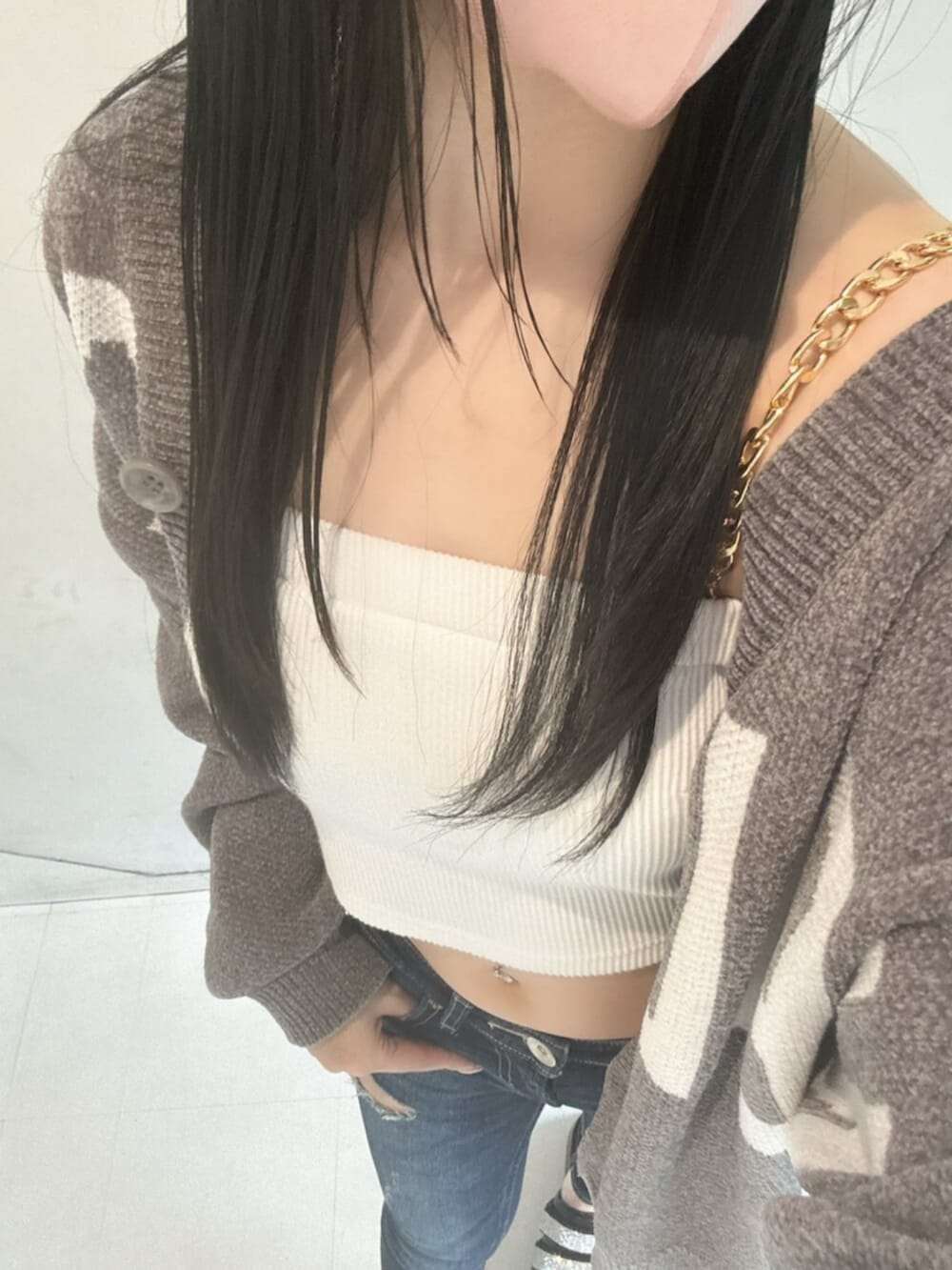 ホワイト系のチューブトップ、グレー系のカーディガン/ボレロ、ブルー系のデニムパンツを着用したレディースの春コーディネートの4枚目の写真