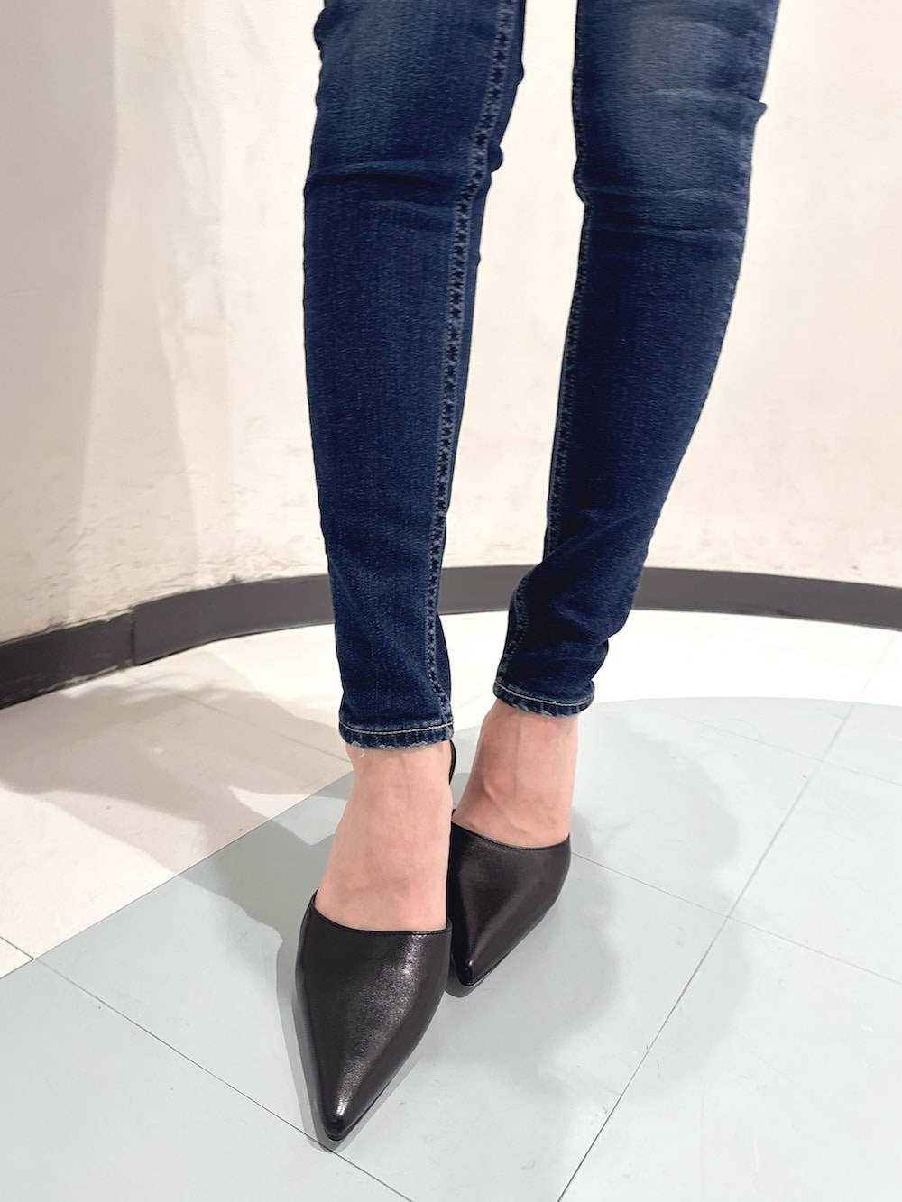 ブルー系のデニムパンツ、ブラック系のパンプス、ブラック系のニット/セーターを着用したレディースの秋コーディネートの6枚目の写真