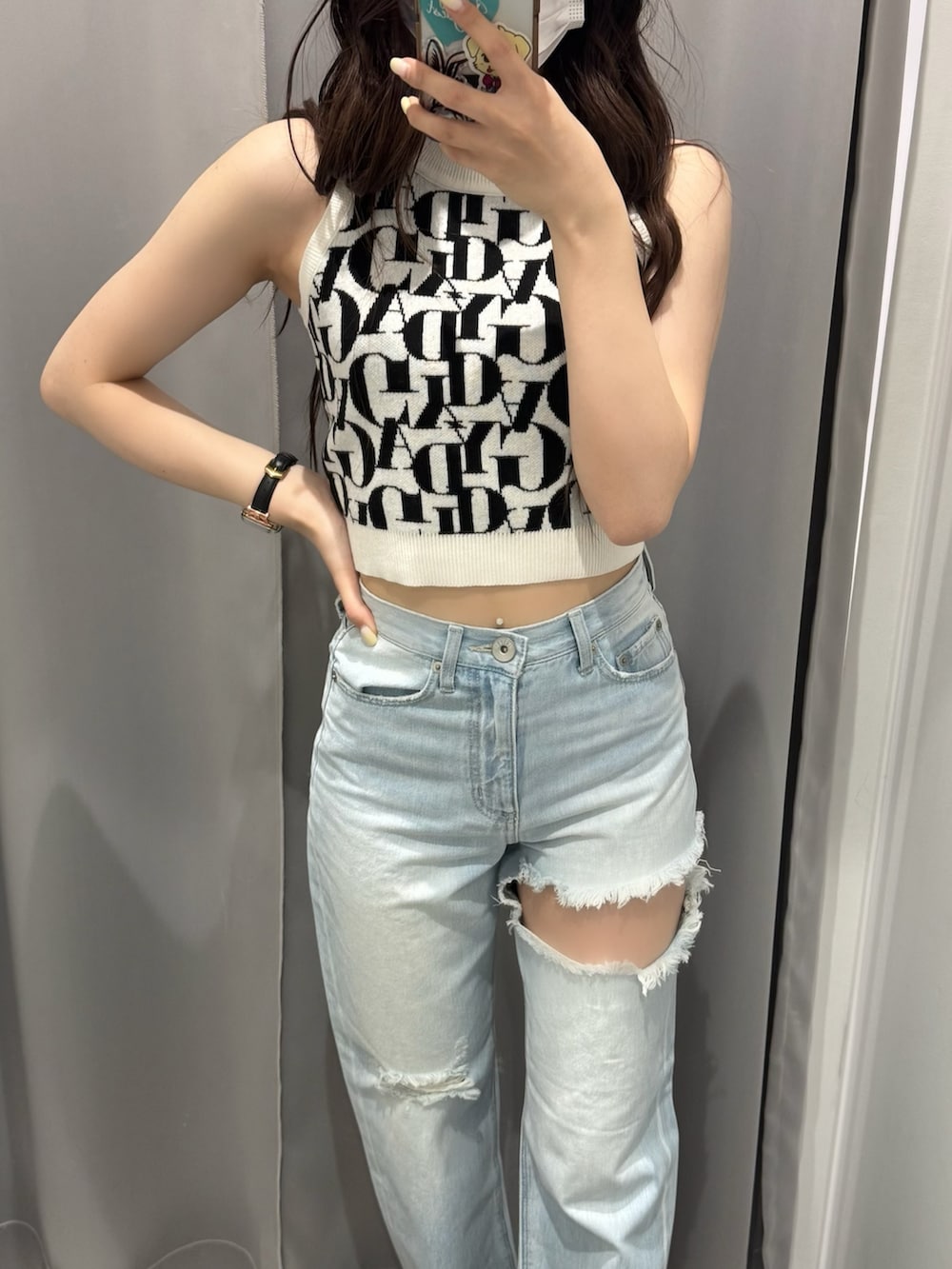 ブルー系のデニムパンツ、ホワイト系のニット/セーター、ホワイト系のサンダルを着用したレディースの春コーディネートの4枚目の写真