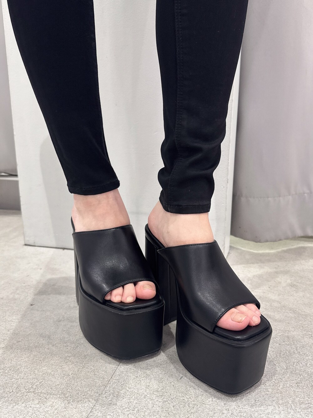 ホワイト系のタンクトップ、ブラック系のデニムパンツ、ブラック系のサンダルを着用したレディースの夏コーディネートの7枚目の写真