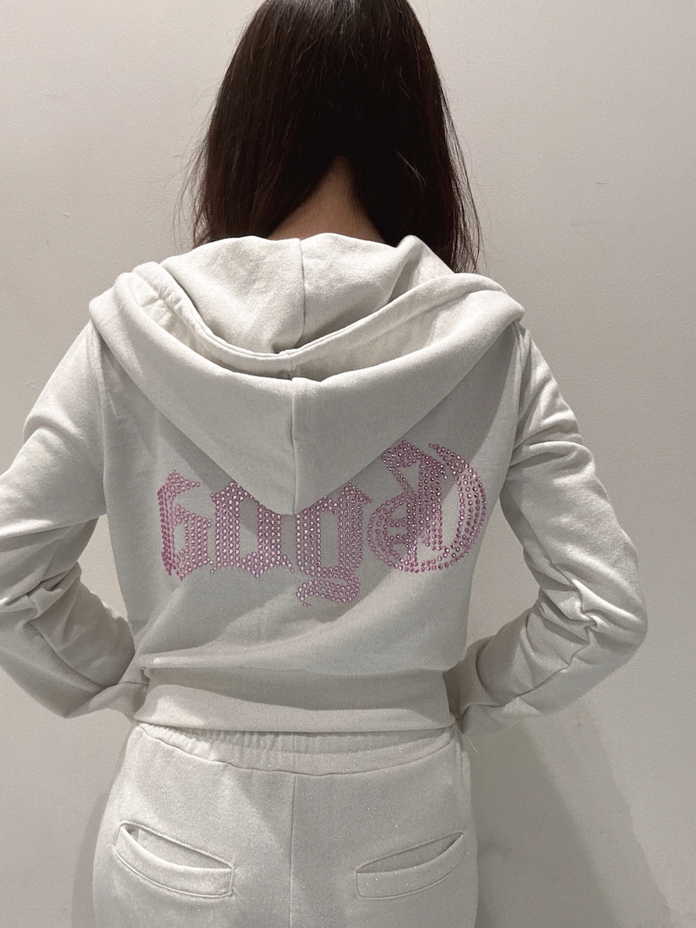 ブラック系のキャミソール、ホワイト系のパーカー、ホワイト系のスウェットパンツを着用したレディースの春コーディネートの4枚目の写真