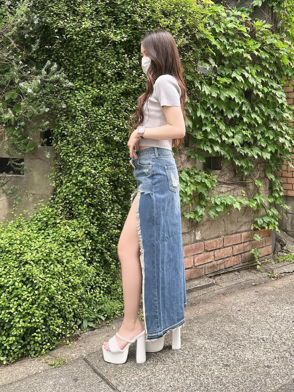 シルバー系のニット/セーター、ブルー系のデニムスカート、ホワイト系のサンダルを着用したレディースの春コーディネートの3枚目の写真