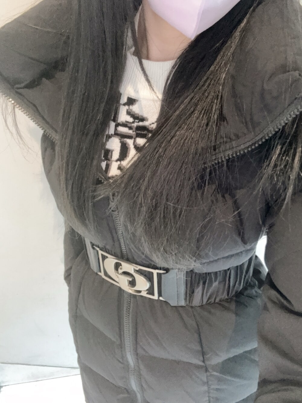 ホワイト系のニット/セーター、ブラック系のデニムスカート、ブラック系のダウンジャケット/コートを着用したレディースの秋コーディネートの6枚目の写真