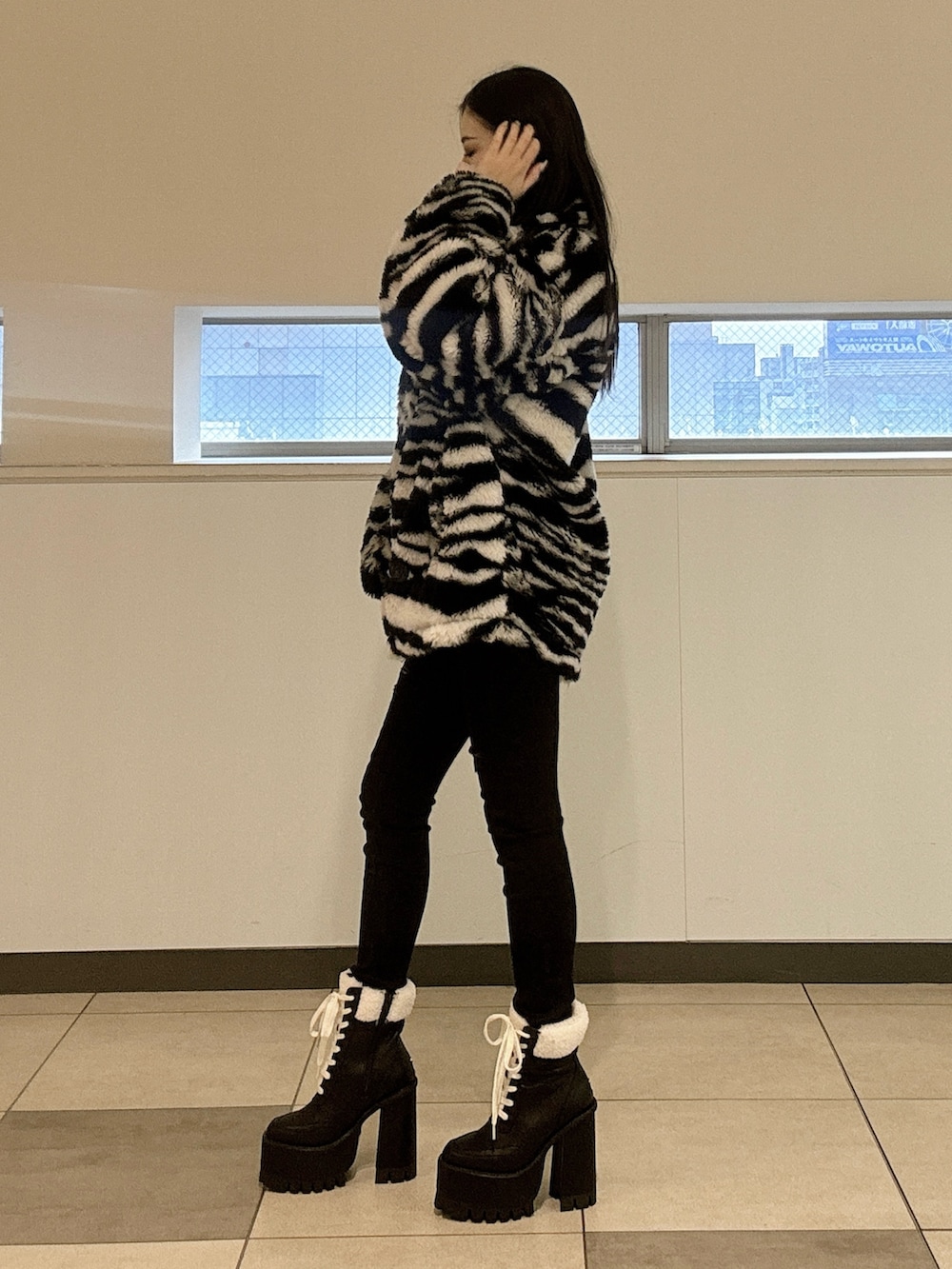 ホワイト系のニット/セーター、その他のブルゾン、ブラック系のブーツを着用したレディースの冬コーディネートの2枚目の写真