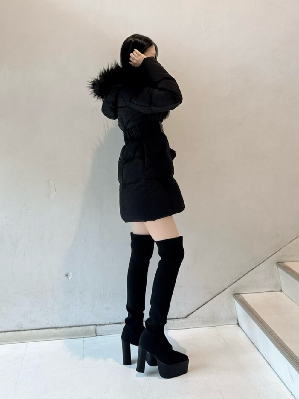 ホワイト系のニット/セーター、ブラック系のデニムスカート、ブラック系のダウンジャケット/コートを着用したレディースの秋コーディネートの2枚目の写真