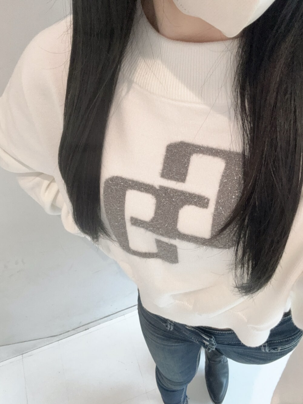 ブラック系のブーツ、ブルー系のデニムパンツ、ホワイト系のニット/セーターを着用したレディースの秋コーディネートの4枚目の写真