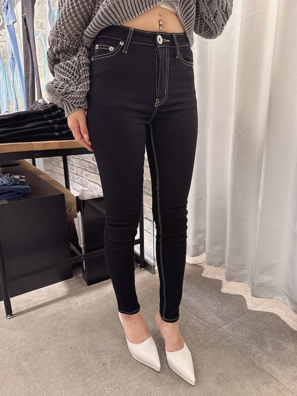 ホワイト系のキャミソール、グレー系のニット/セーター、ブラック系のデニムパンツを着用したレディースの春コーディネートの4枚目の写真