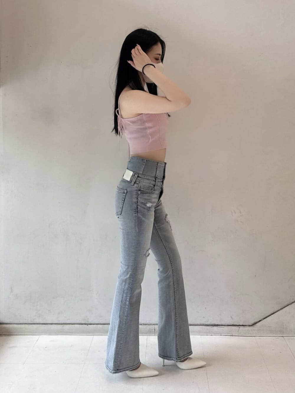 ホワイト系のパンプス、ピンク系のキャミソール、ブルー系のデニムパンツを着用したレディースの春コーディネートの3枚目の写真