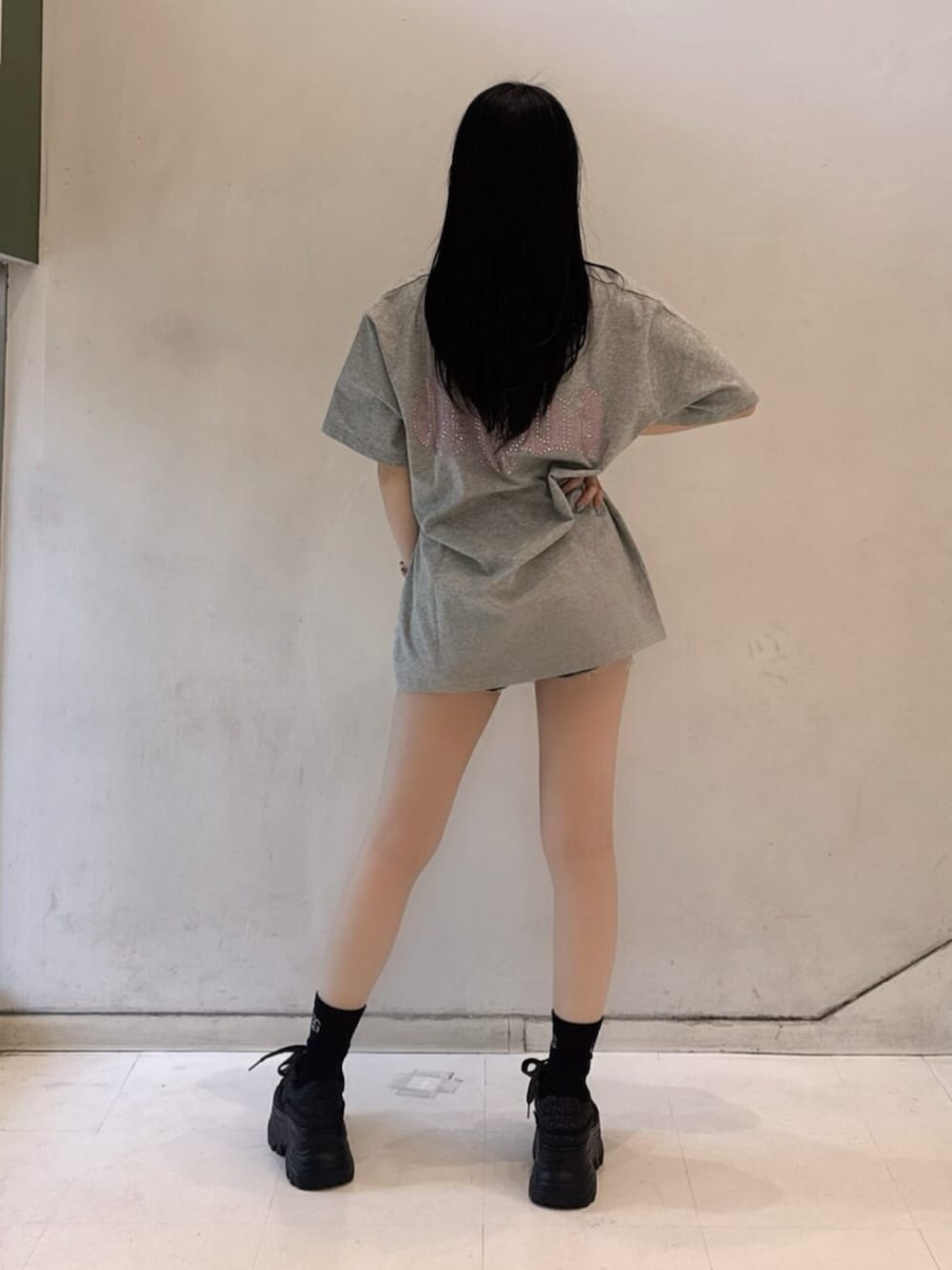 グレー系のTシャツ/カットソー、ブルー系のデニムパンツ、ブラック系のスニーカーを着用したレディースの春コーディネートの4枚目の写真
