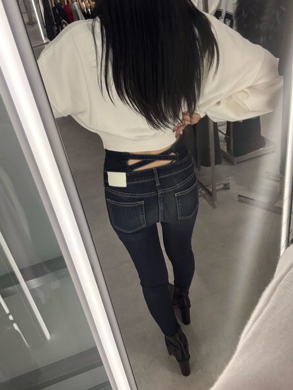 ブラック系のブーツ、ブルー系のデニムパンツ、ホワイト系のニット/セーターを着用したレディースの秋コーディネートの5枚目の写真