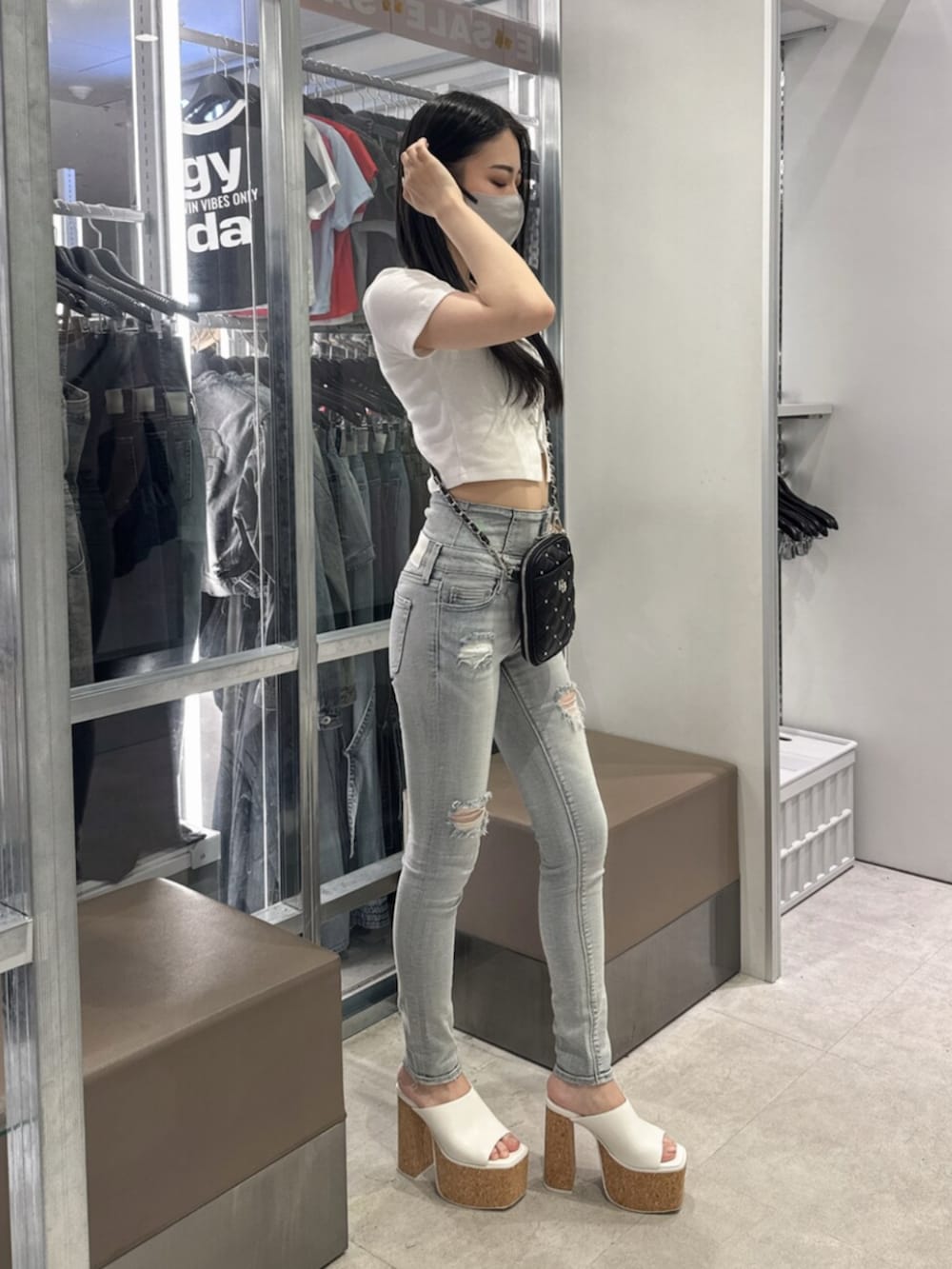 ホワイト系のサンダル、ホワイト系のTシャツ/カットソー、ブルー系のデニムパンツを着用したレディースの夏コーディネートの2枚目の写真