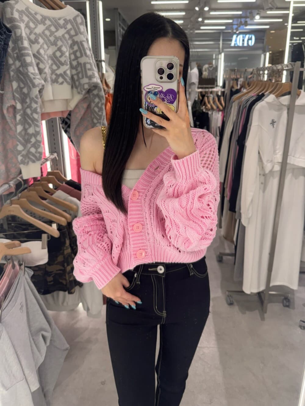 ブラック系のデニムパンツ、ホワイト系のキャミソール、ピンク系のニット/セーターを着用したレディースの春コーディネートの5枚目の写真