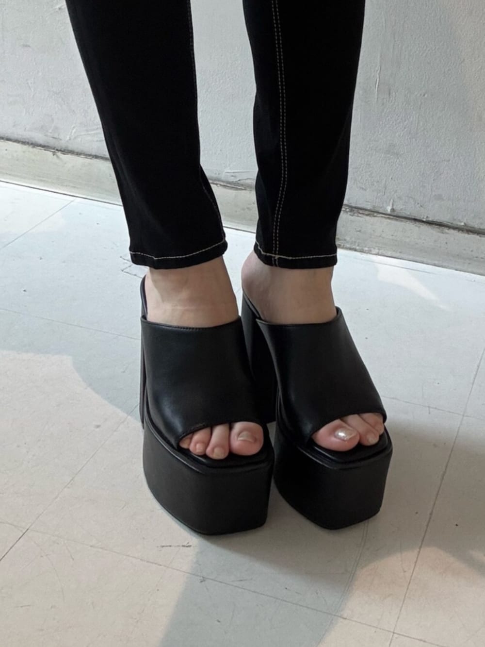 ブラック系のデニムパンツ、その他のタンクトップ、ブラック系のベストを着用したレディースの春コーディネートの6枚目の写真