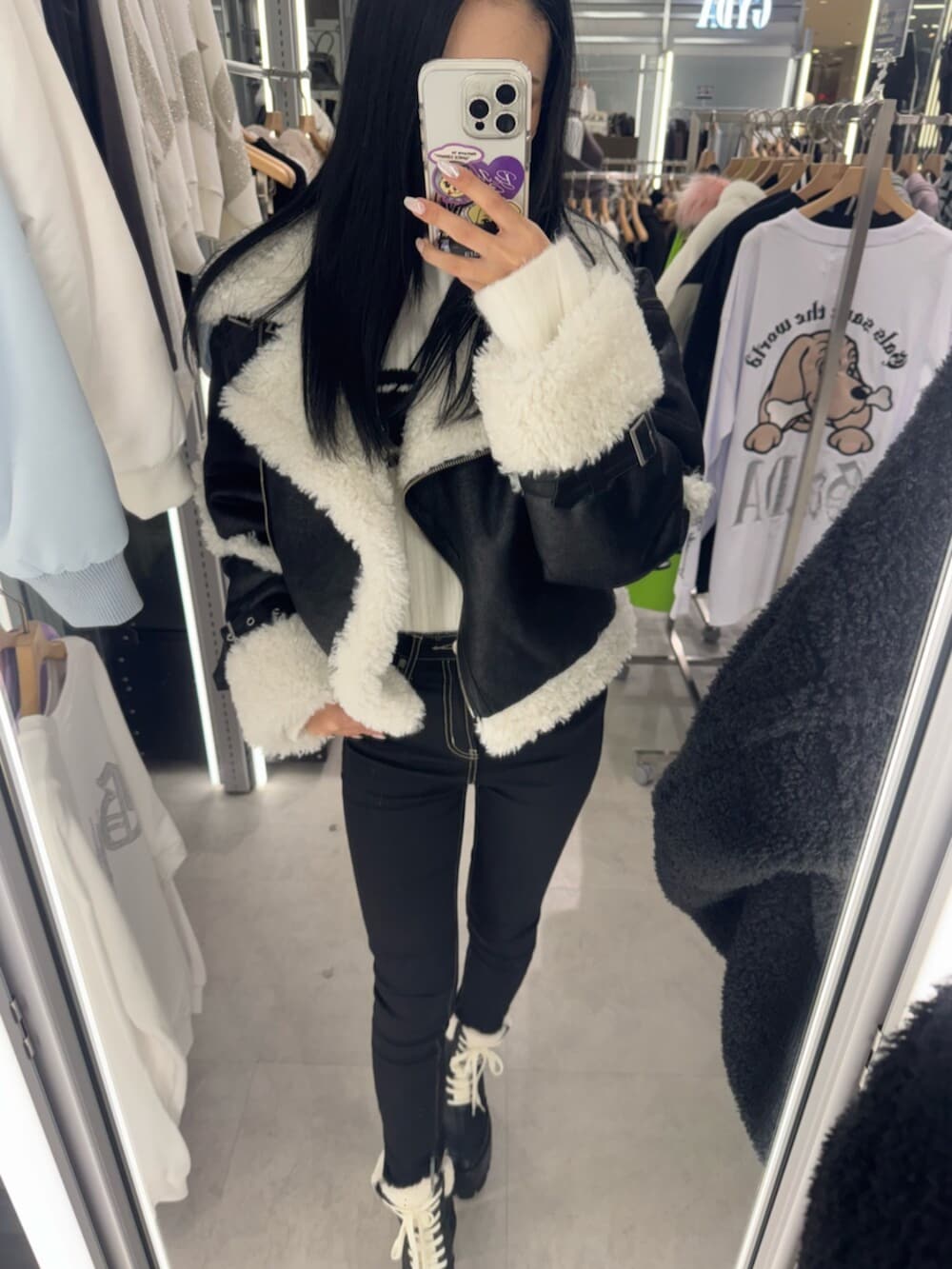 ブラック系のブーツ、ホワイト系のニット/セーター、ブラック系のムートンコートを着用したレディースの冬コーディネートの4枚目の写真