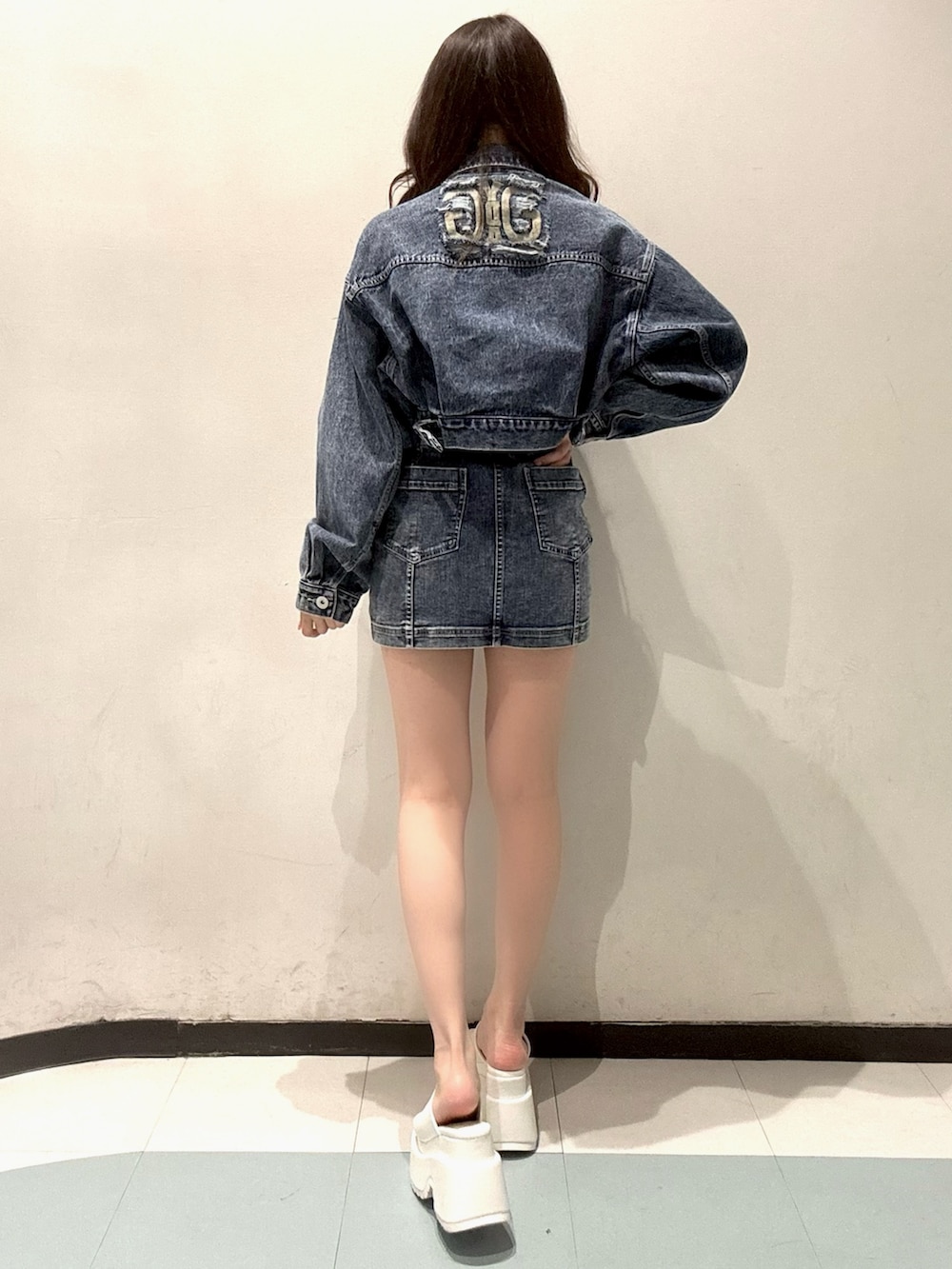 ブルー系のデニムジャケット、ブルー系のワンピース、ホワイト系のサンダルを着用したレディースの春コーディネートの3枚目の写真