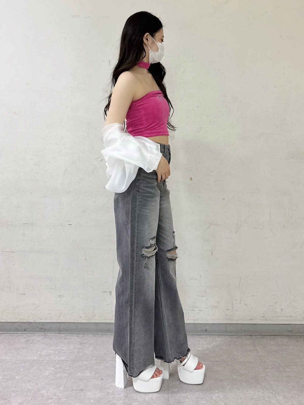 ピンク系のチューブトップ、ホワイト系のシャツ/ブラウス、グレー系のデニムパンツを着用したレディースの春コーディネートの2枚目の写真