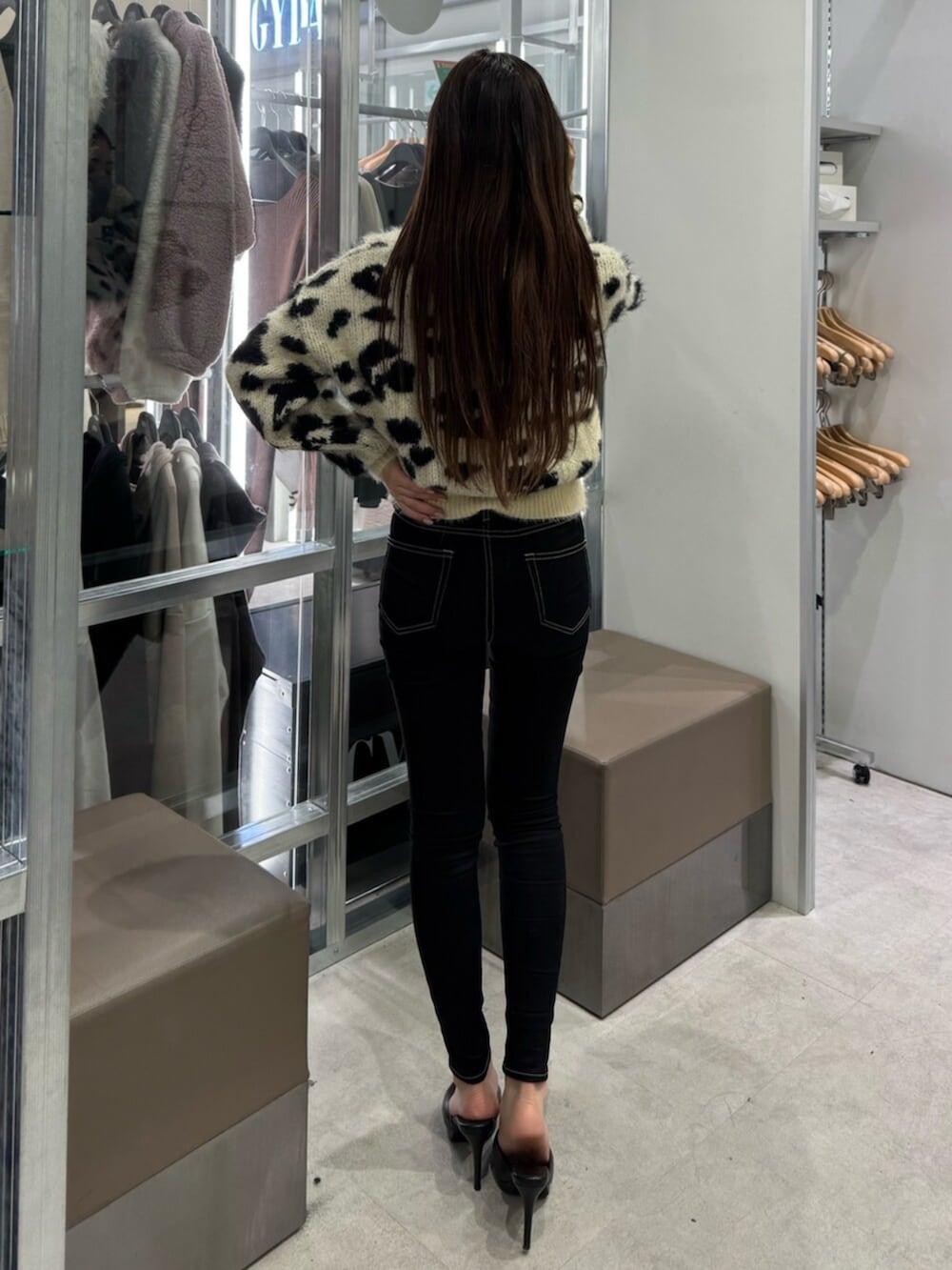 ホワイト系のニット/セーター、ブラック系のデニムパンツ、ブラック系のパンプスを着用したレディースの冬コーディネートの3枚目の写真