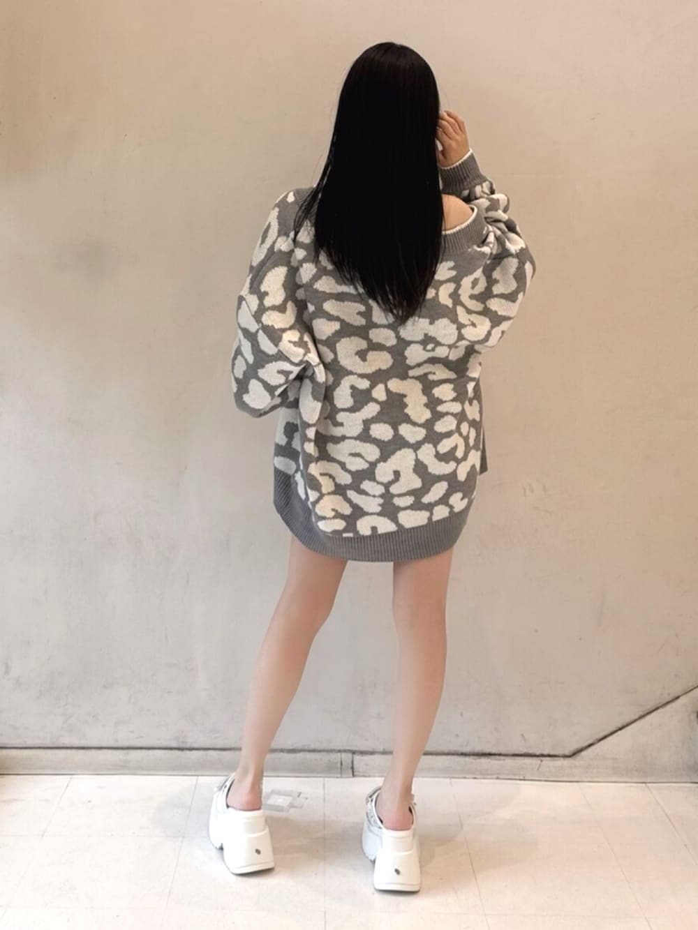 ブラック系のワンピース、グレー系のカーディガン/ボレロ、ホワイト系のサンダルを着用したレディースの春コーディネートの3枚目の写真