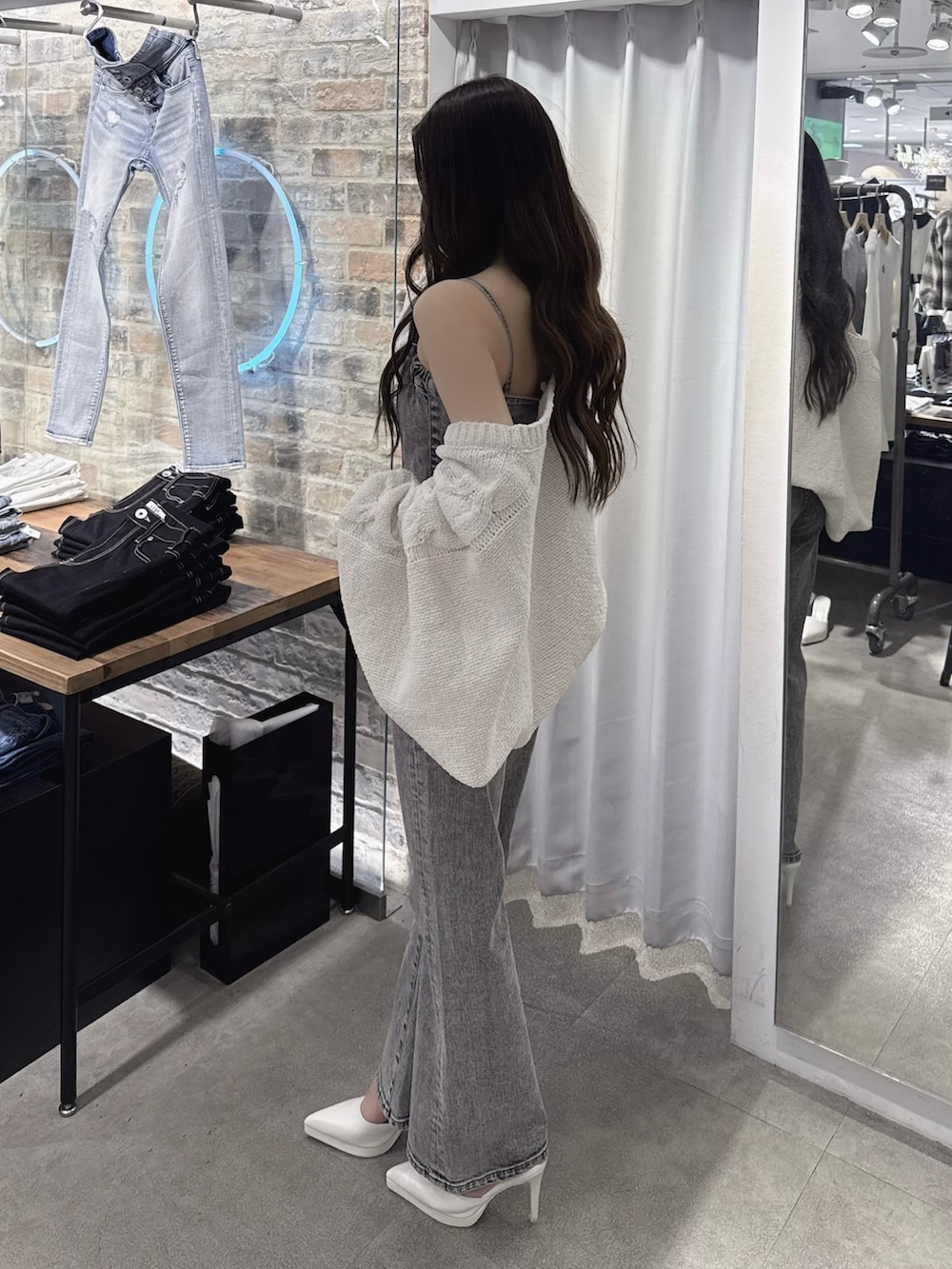 ブラック系のサロペット/オーバーオール、ホワイト系のパンプス、ホワイト系のカーディガン/ボレロを着用したレディースの春コーディネートの2枚目の写真