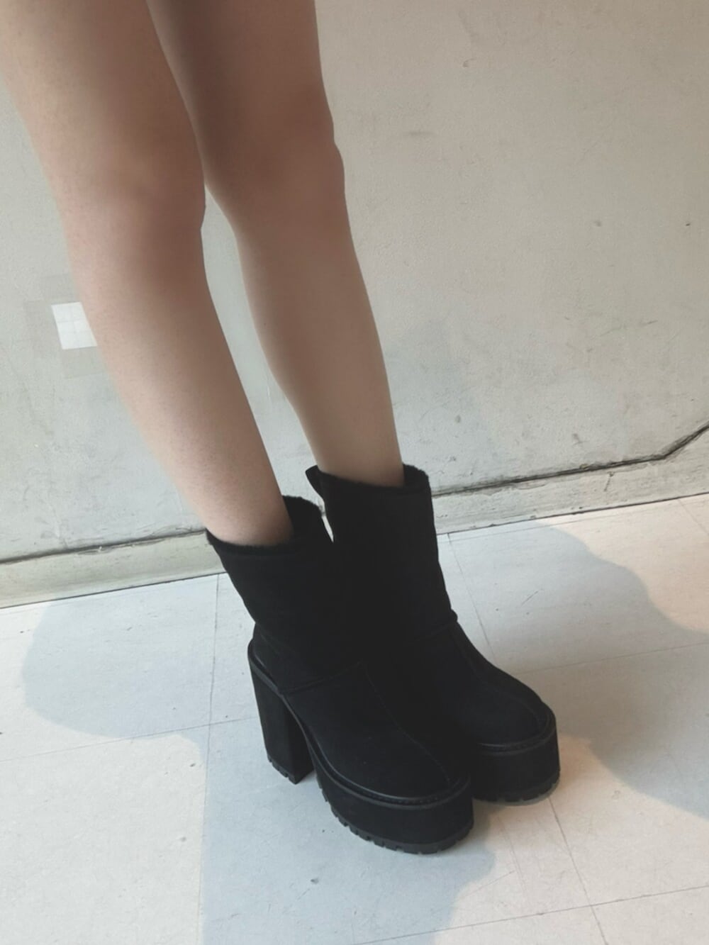 ブラック系のスカート、ブラック系のブーツ、ピンク系のスウェットを着用したレディースの冬コーディネートの5枚目の写真