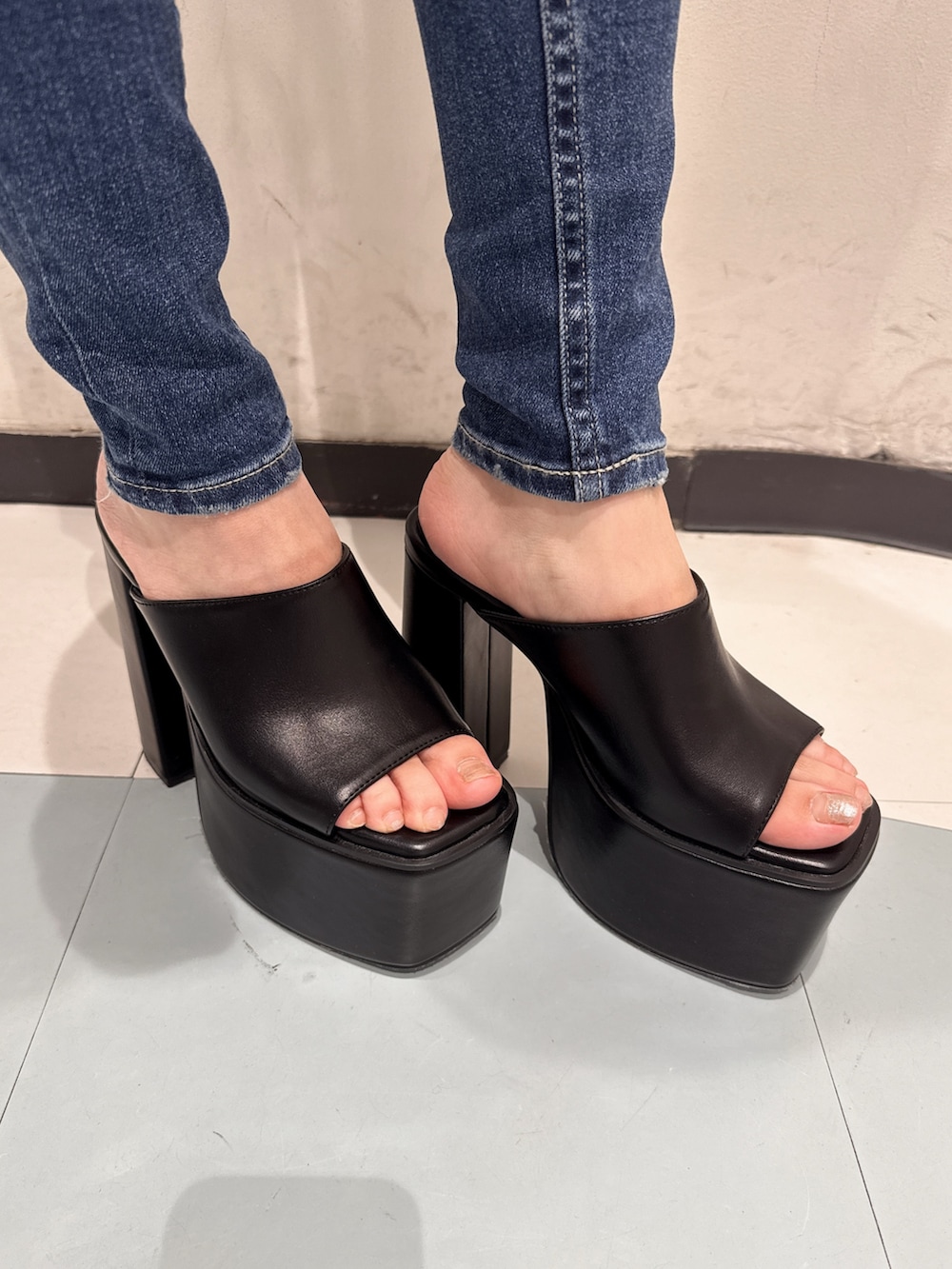 ホワイト系のキャミソール、ブルー系のデニムパンツ、ブラック系のサンダルを着用したレディースの夏コーディネートの6枚目の写真