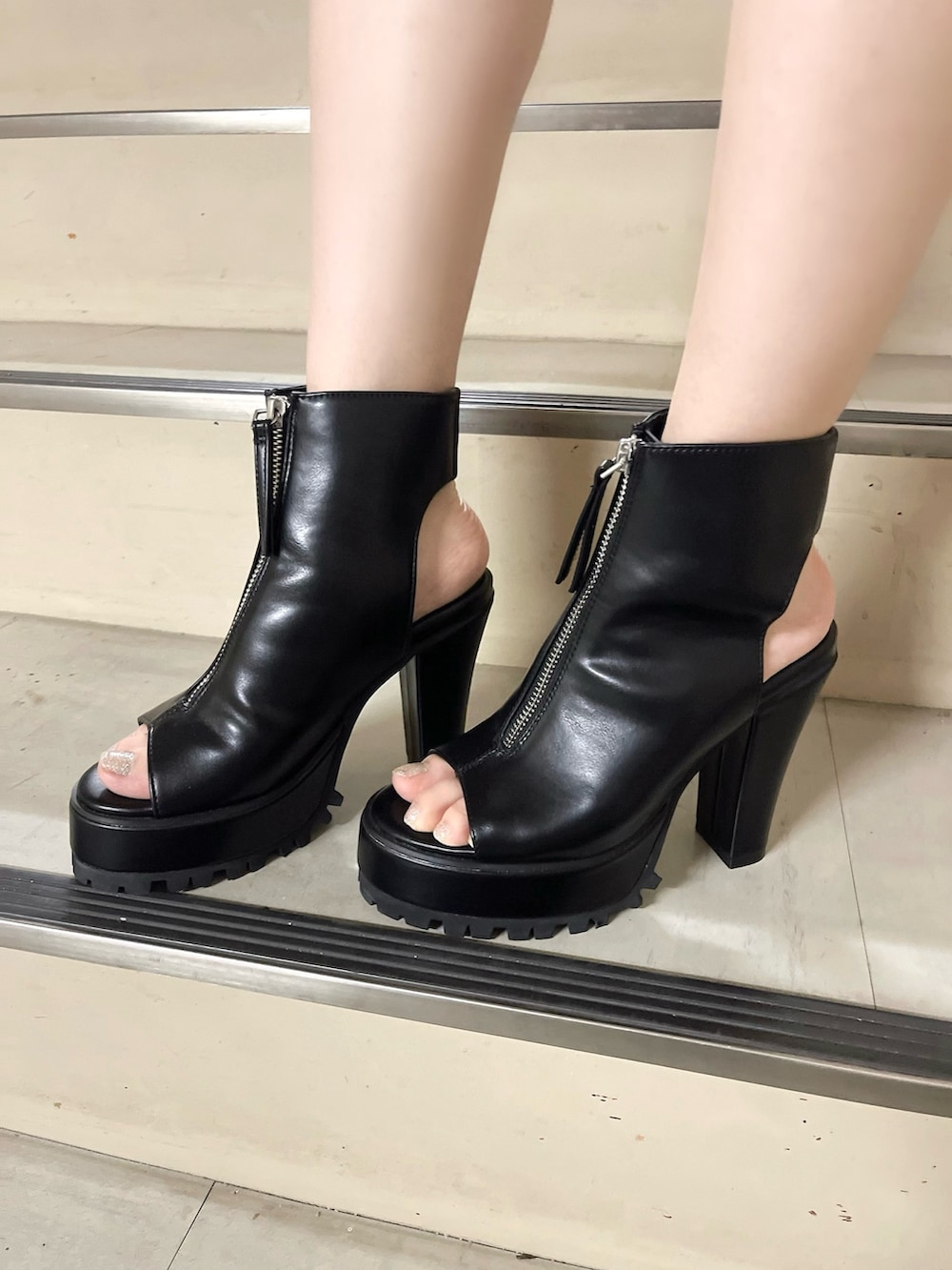 ブラック系のワンピース、ブラック系のブーツを着用したレディースの夏コーディネートの5枚目の写真