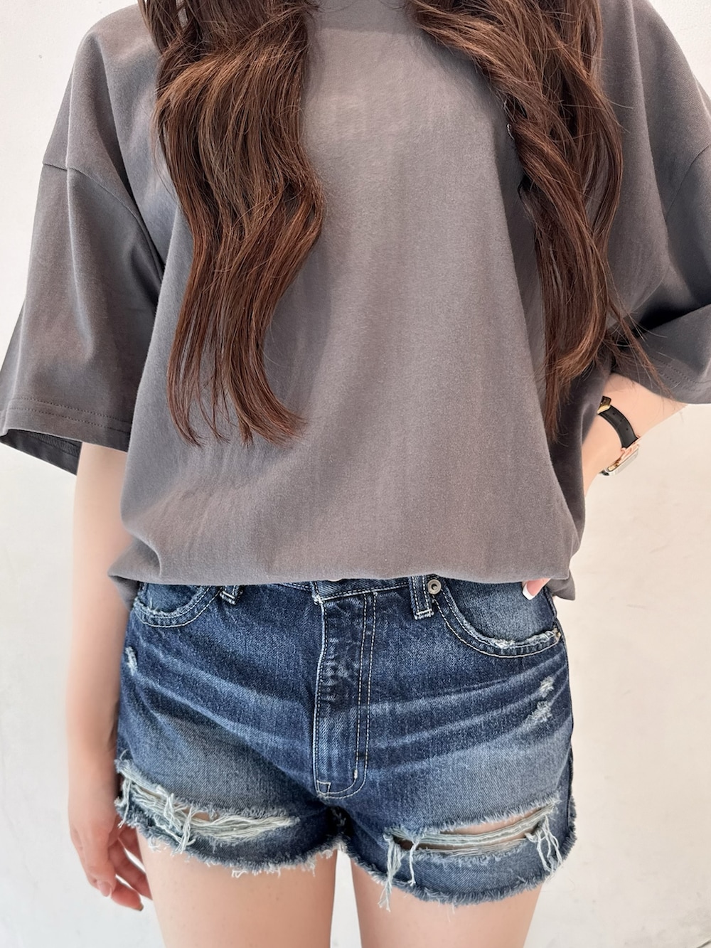 ホワイト系のTシャツ/カットソー、ブルー系のデニムパンツ、ブラック系のブーツを着用したレディースの春コーディネートの6枚目の写真