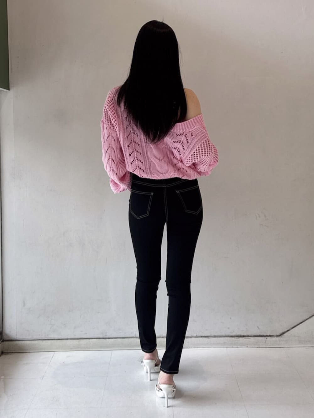 ブラック系のデニムパンツ、ホワイト系のキャミソール、ピンク系のニット/セーターを着用したレディースの春コーディネートの3枚目の写真