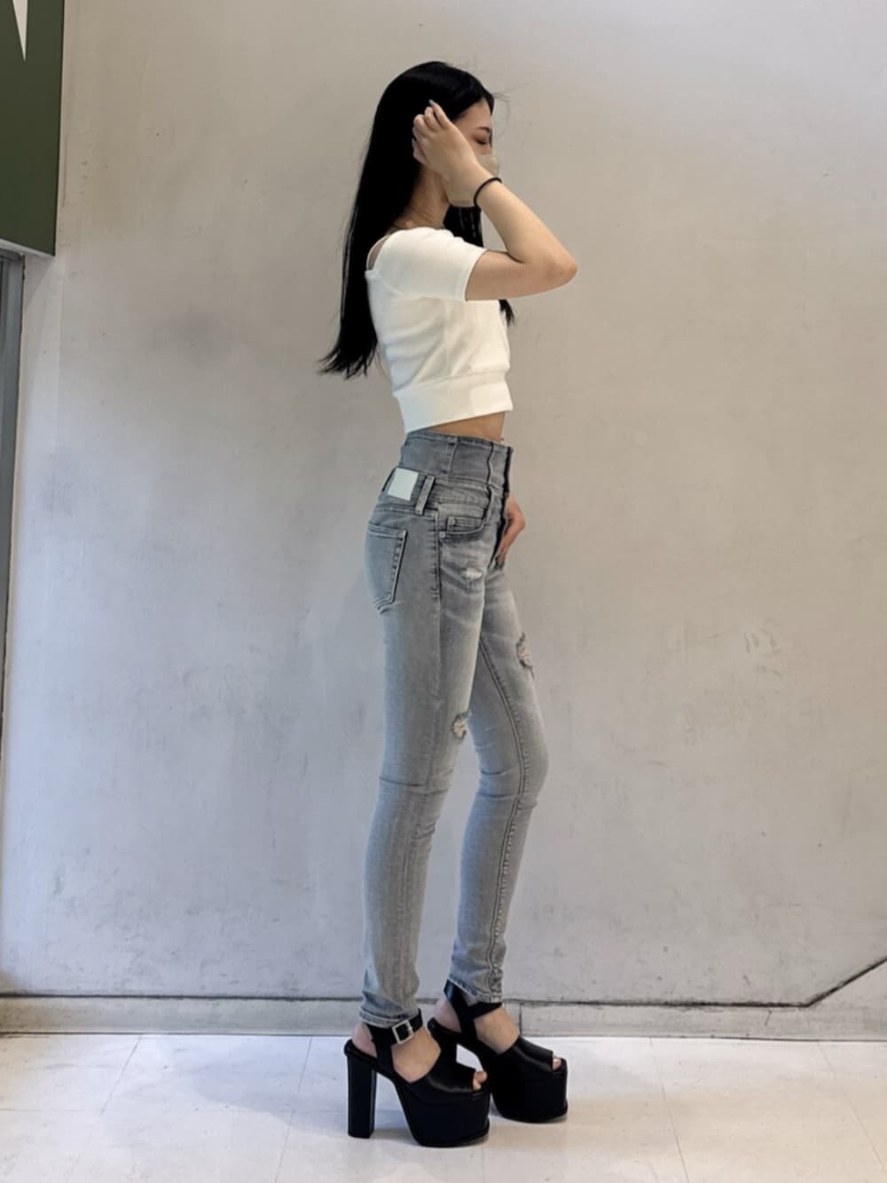 ホワイト系のTシャツ/カットソー、ブルー系のデニムパンツ、ブラック系のサンダルを着用したレディースの春コーディネートの2枚目の写真