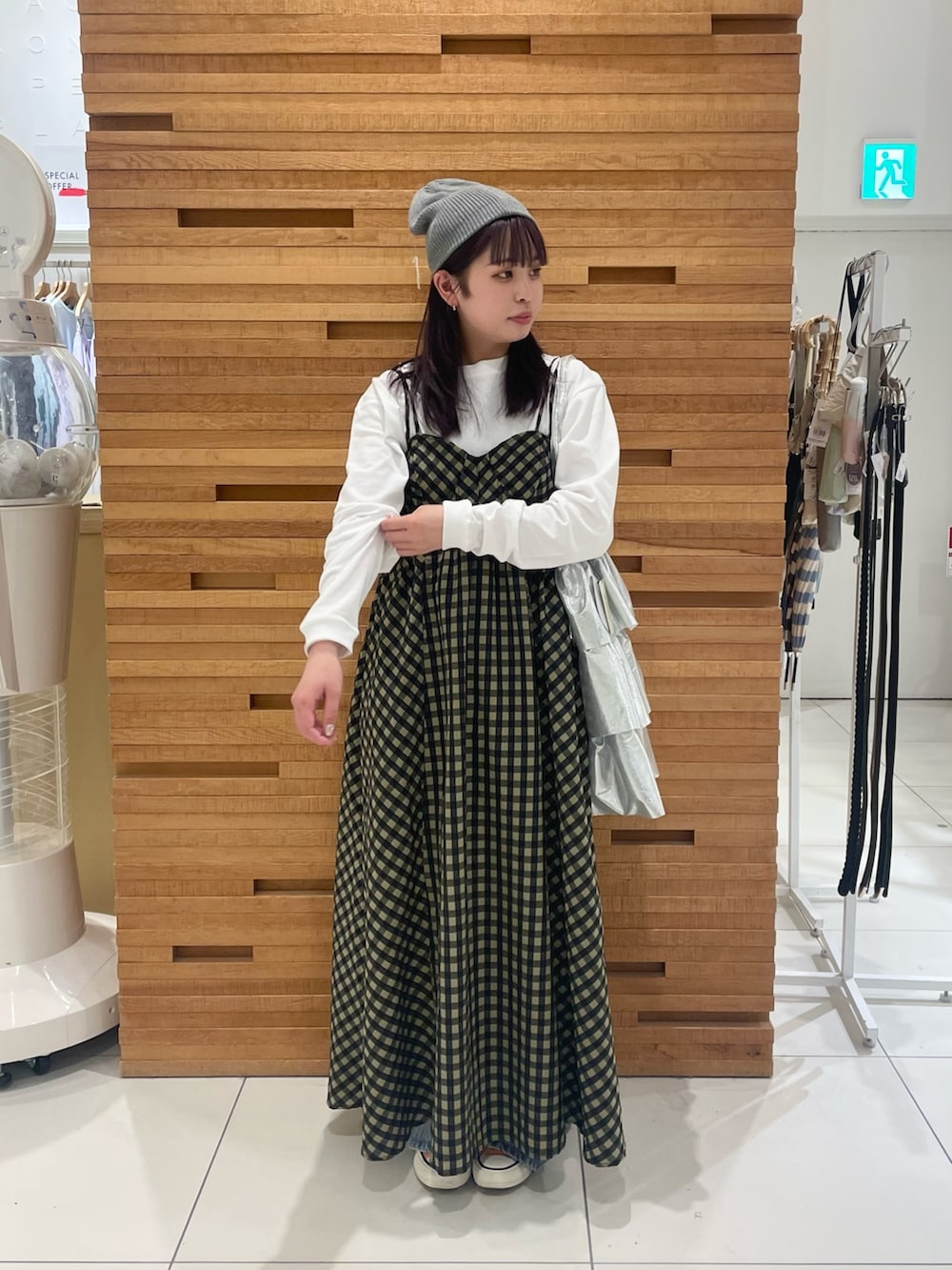 グリーン系のワンピース、ホワイト系のTシャツ/カットソー、シルバー系のトートバッグを着用したレディースの春コーディネートの2枚目の写真