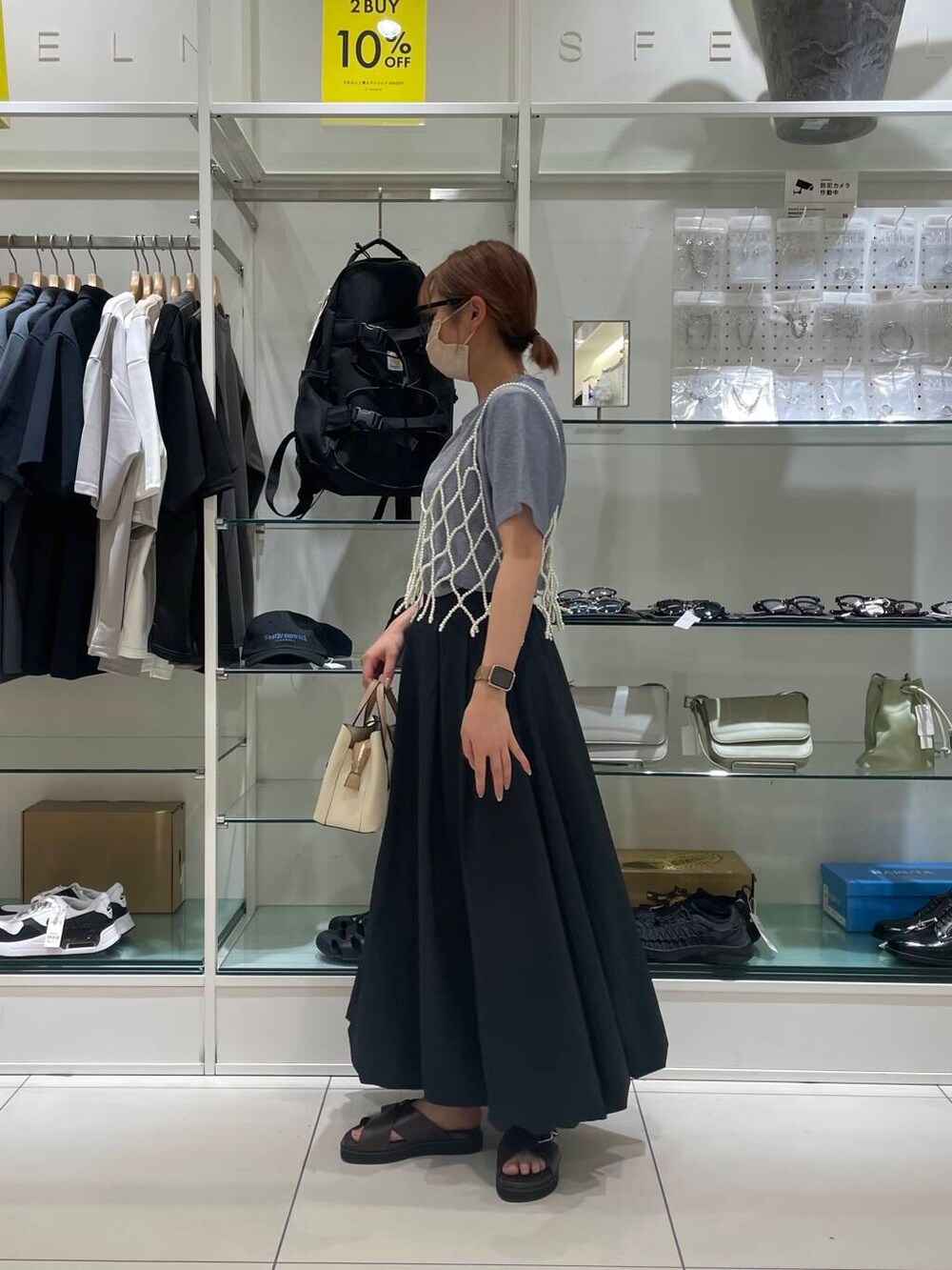 ホワイト系のハンドバッグ、ブラウン系のサンダル、ブルー系のTシャツ/カットソーを着用したレディースの夏コーディネートの2枚目の写真
